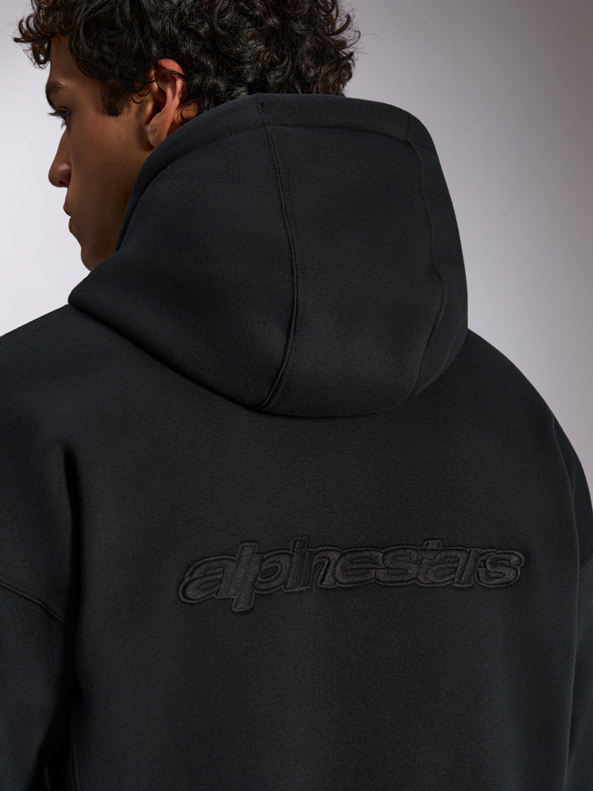 Alpinestars Emergent Oversized Hoodie, black casual streetwear, back view featuring 3D embroidered Alpinestars word logo, oversized fit with premium fleece texture