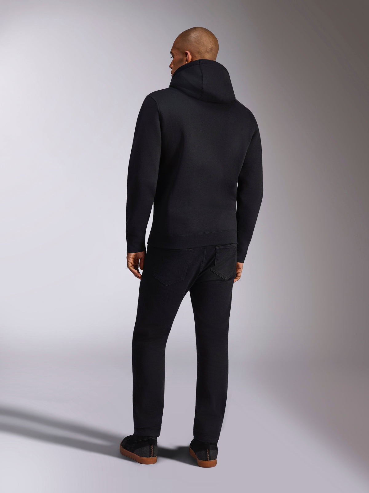 Alpinestars Ellipsoid Hoodie, casual sportswear, solid black hooded pullover fleece, back view, features long sleeves and ribbed hem, paired with black pants, modern motorsport-inspired design