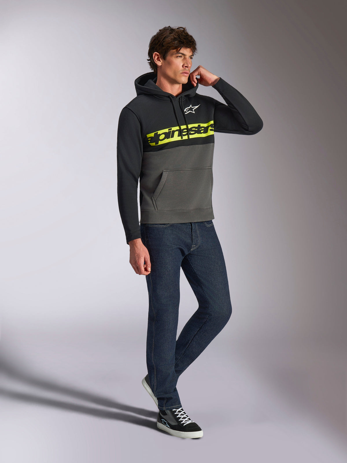 Alpinestars Parallel Hoodie, casual streetwear, color-blocked black and gunmetal grey, neon yellow Alpinestars word logo on chest, white Astars logo, drawstring hood, worn with dark jeans and sneakers