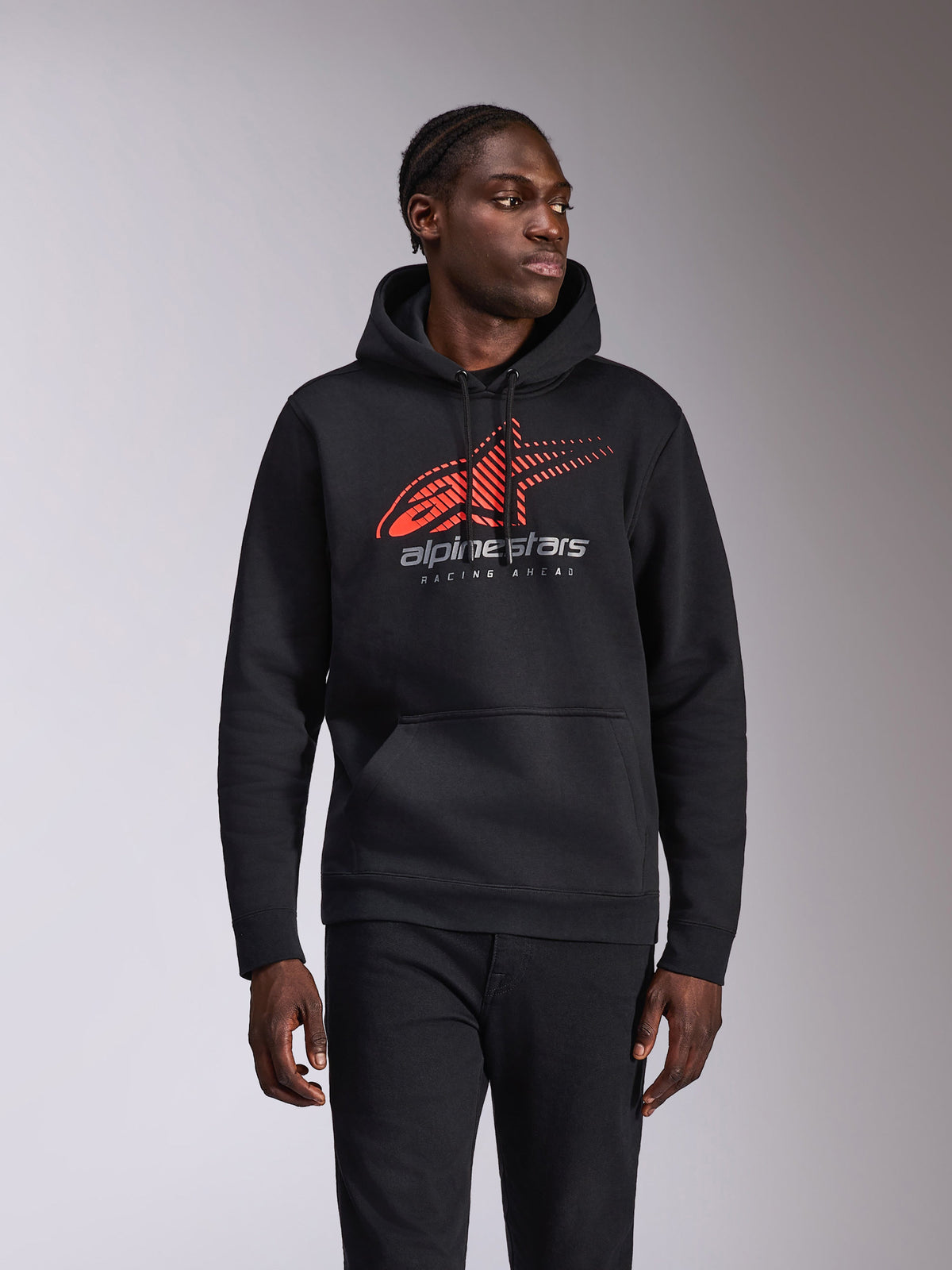 Alpinestars Pulse Hoodie, casual pullover hoodie, black with red and grey Astars logo featuring speed line fade and 'Racing Ahead' text, drawstring hood and kangaroo pocket, motorsport-inspired streetwear worn by a model