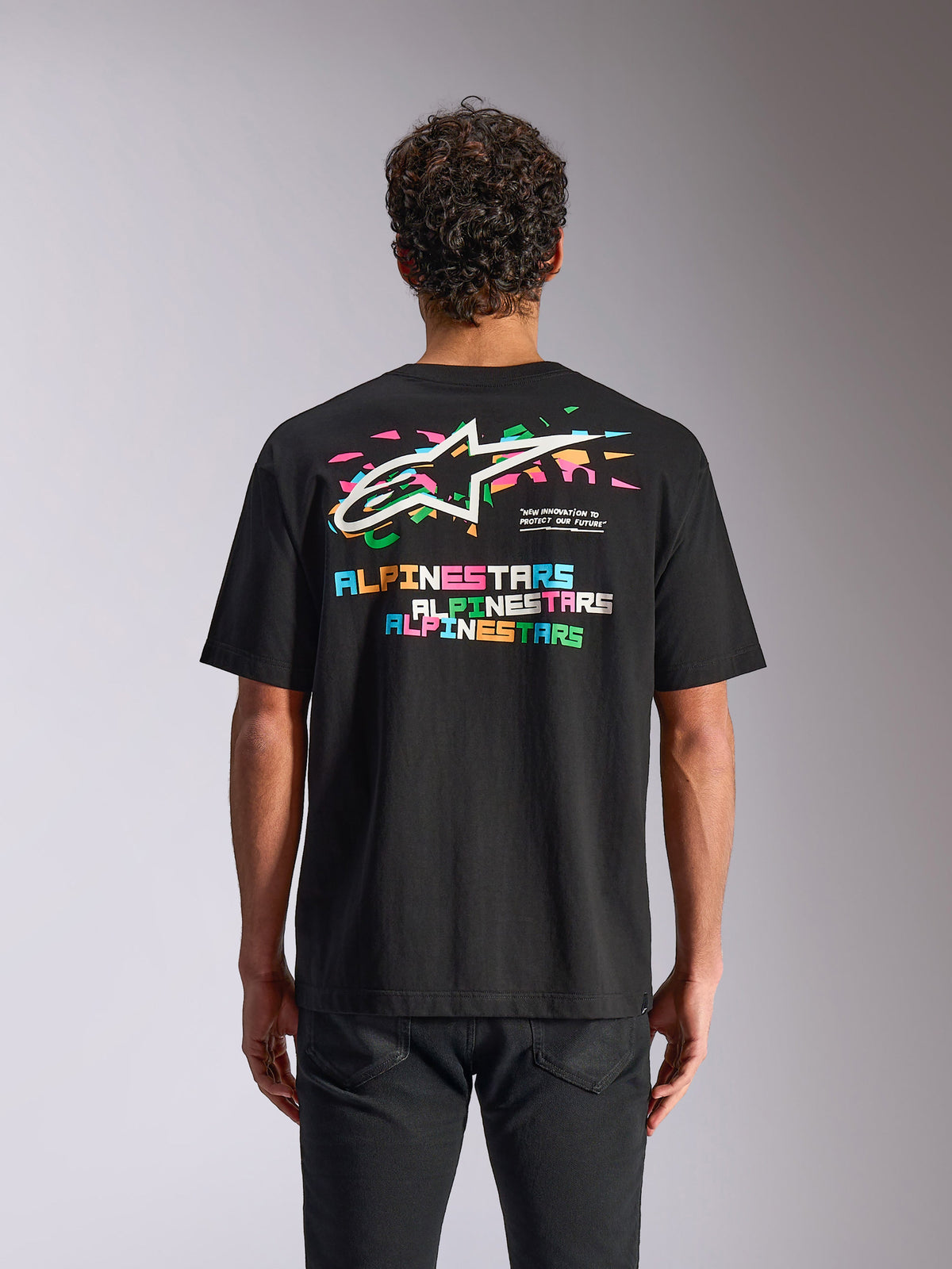Alpinestars Wild Oversized CSF Tee, Short Sleeve T-Shirt, Black, Back view showing vibrant multi-color Astars logo and graphic elements, casual motorsport streetwear