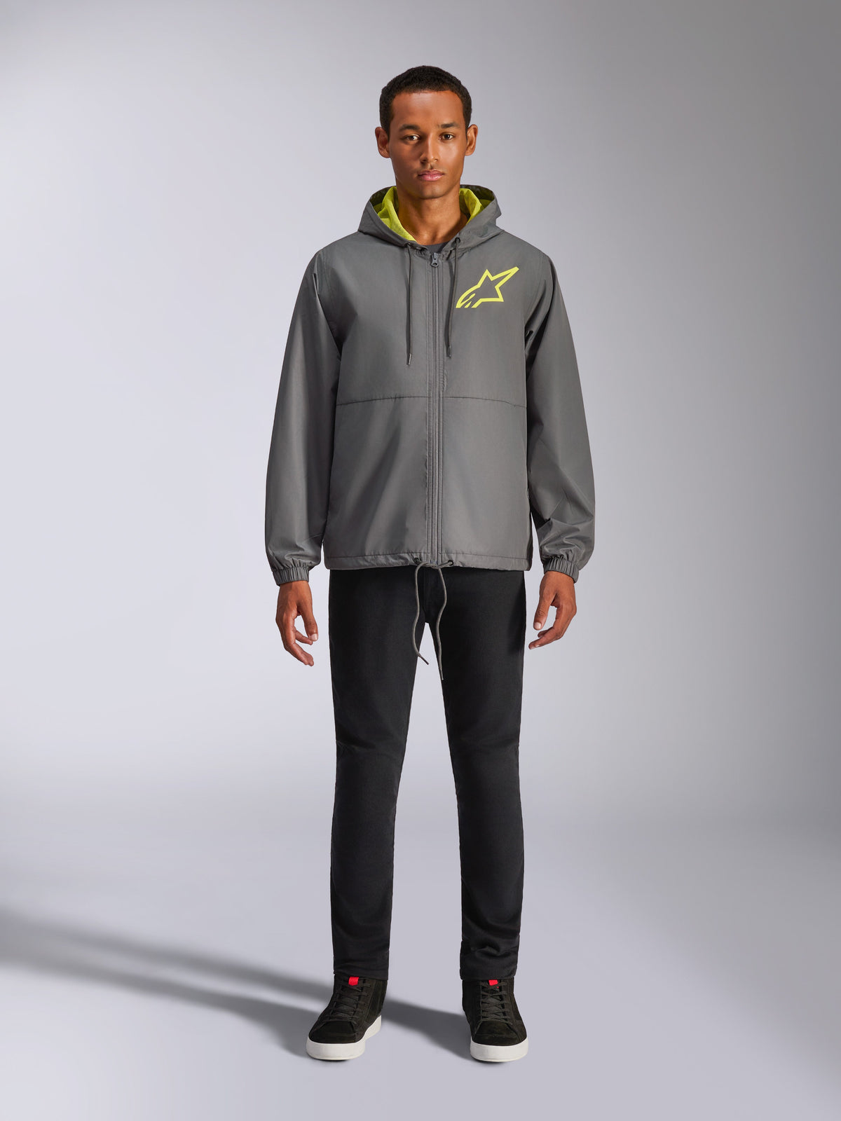 Alpinestars Speeder Chromium Windbreak Jacket, Charcoal gray hooded jacket with high-vis yellow lining and chest logo, full-zip front, elastic cuffs, casual motorsport-inspired streetwear