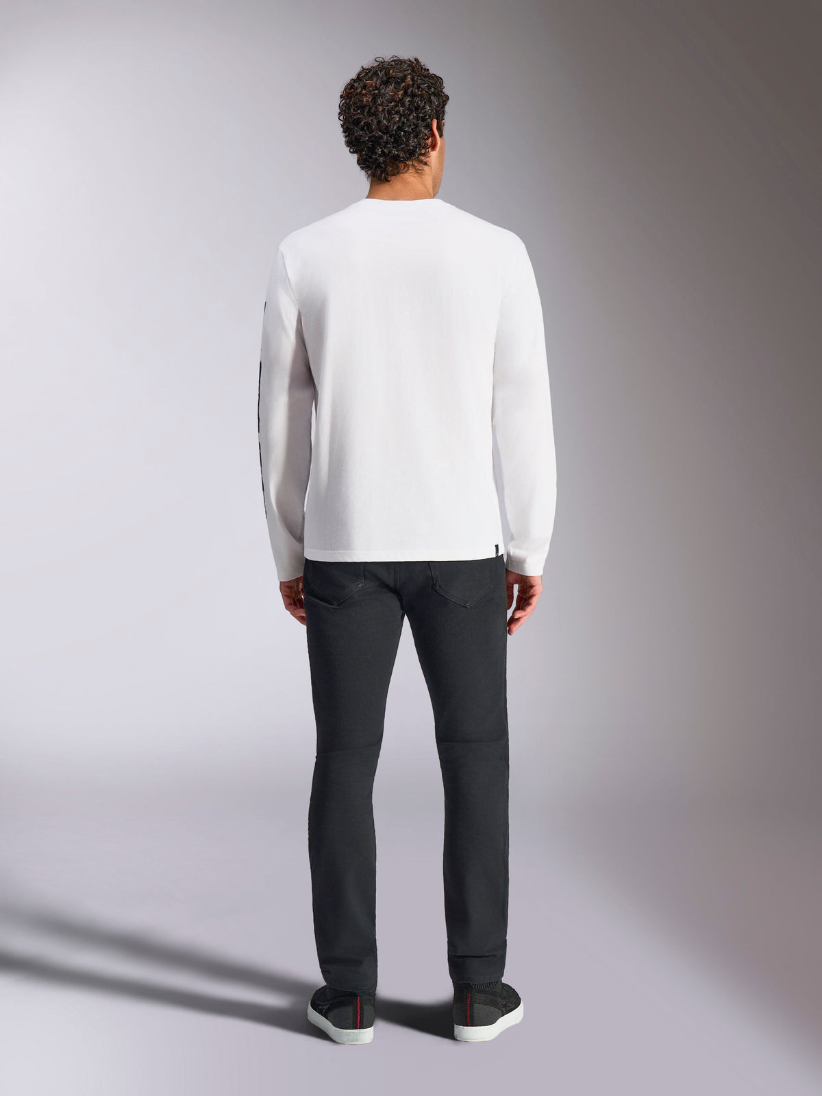 Alpinestars Trackside CSF Tee - Long Sleeve, White, back view of long-sleeve t-shirt, worn with black pants and sneakers, featuring a small black label at the hem, casual motorsport-inspired streetwear