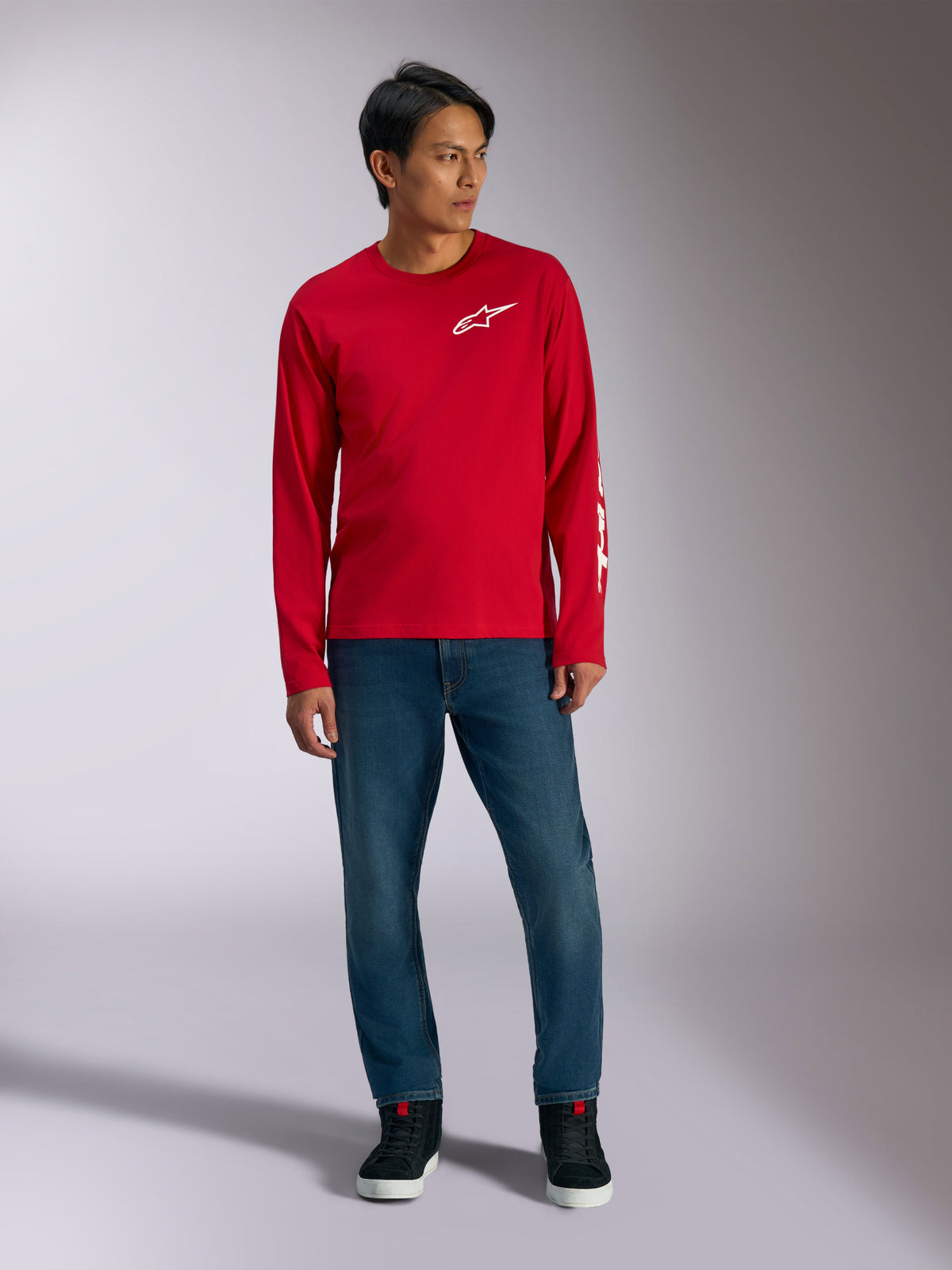 Alpinestars Trackside CSF Tee, Long Sleeve T-Shirt, Red with White Alpinestars Logo, lifestyle shot worn with blue jeans and black sneakers, casual motorsport-inspired sportswear