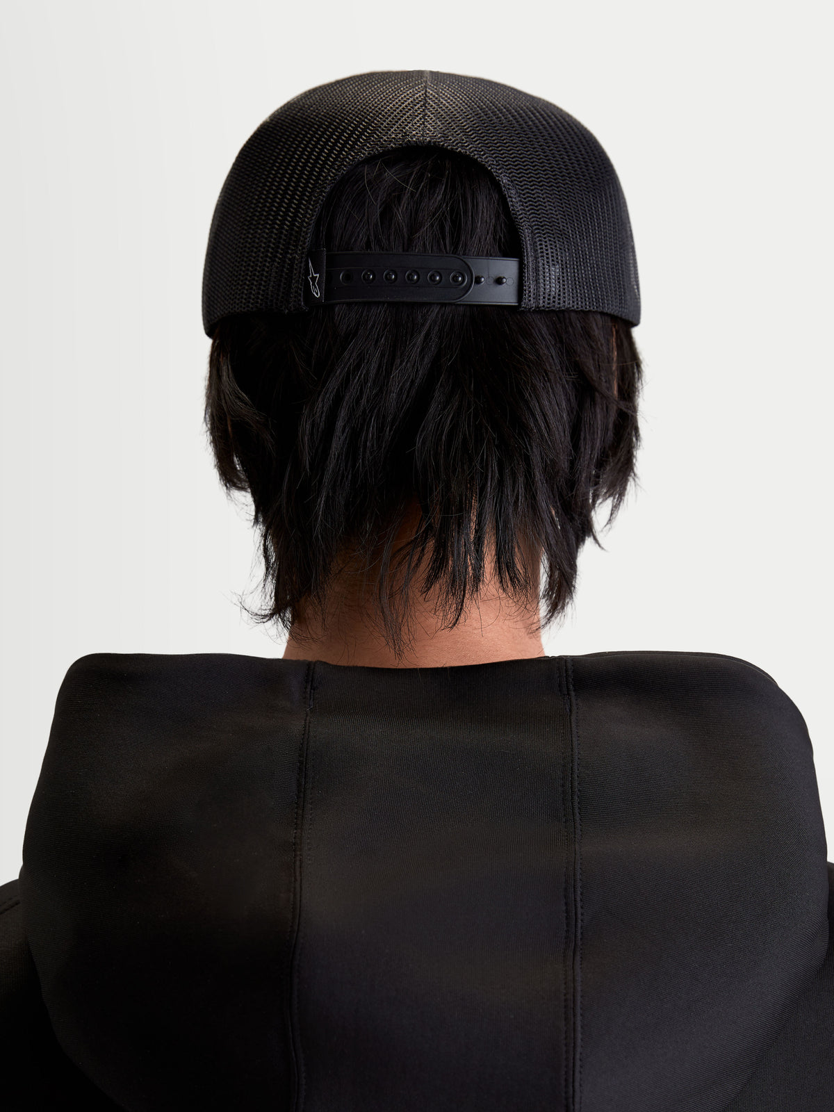 Alpinestars Gravel Trucker Hat, Sportswear Snapback Cap, Unisex, Black, Rear View on Model showing the Breathable Poly Mesh Back and Adjustable Snapback Closure.