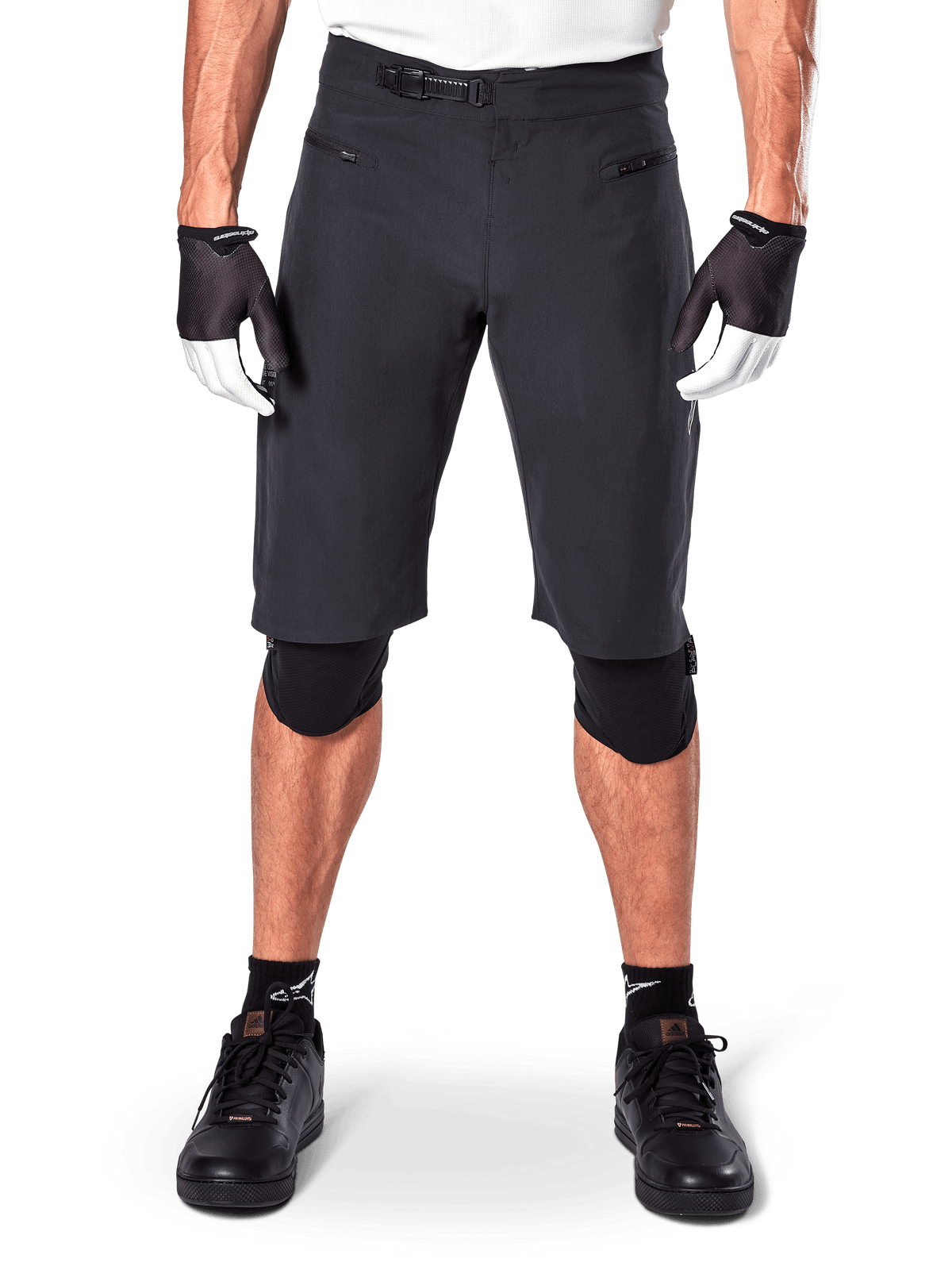 Alpinestars A-Aria Shorts, Black Mountain Bike Shorts, featuring a ratchet waist closure and zippered pockets, worn with black and white gloves and knee pads, technical cycling gear for off-road riding