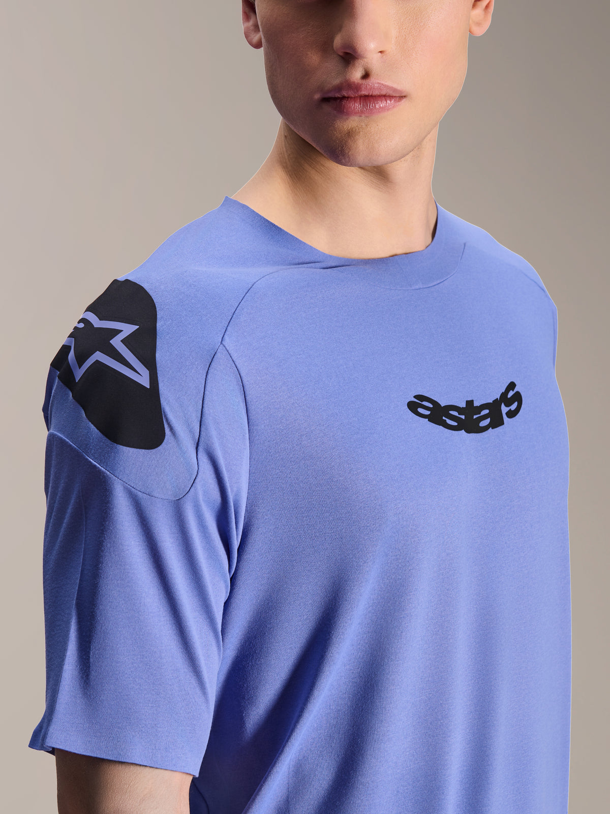 Alpinestars A-Aria Polartec Elite Jersey, Short Sleeve Mountain Bike Jersey, Baja Blue, close-up of chest and shoulder featuring black astars logo and shoulder graphic, technical moisture-wicking fabric for off-road cycling