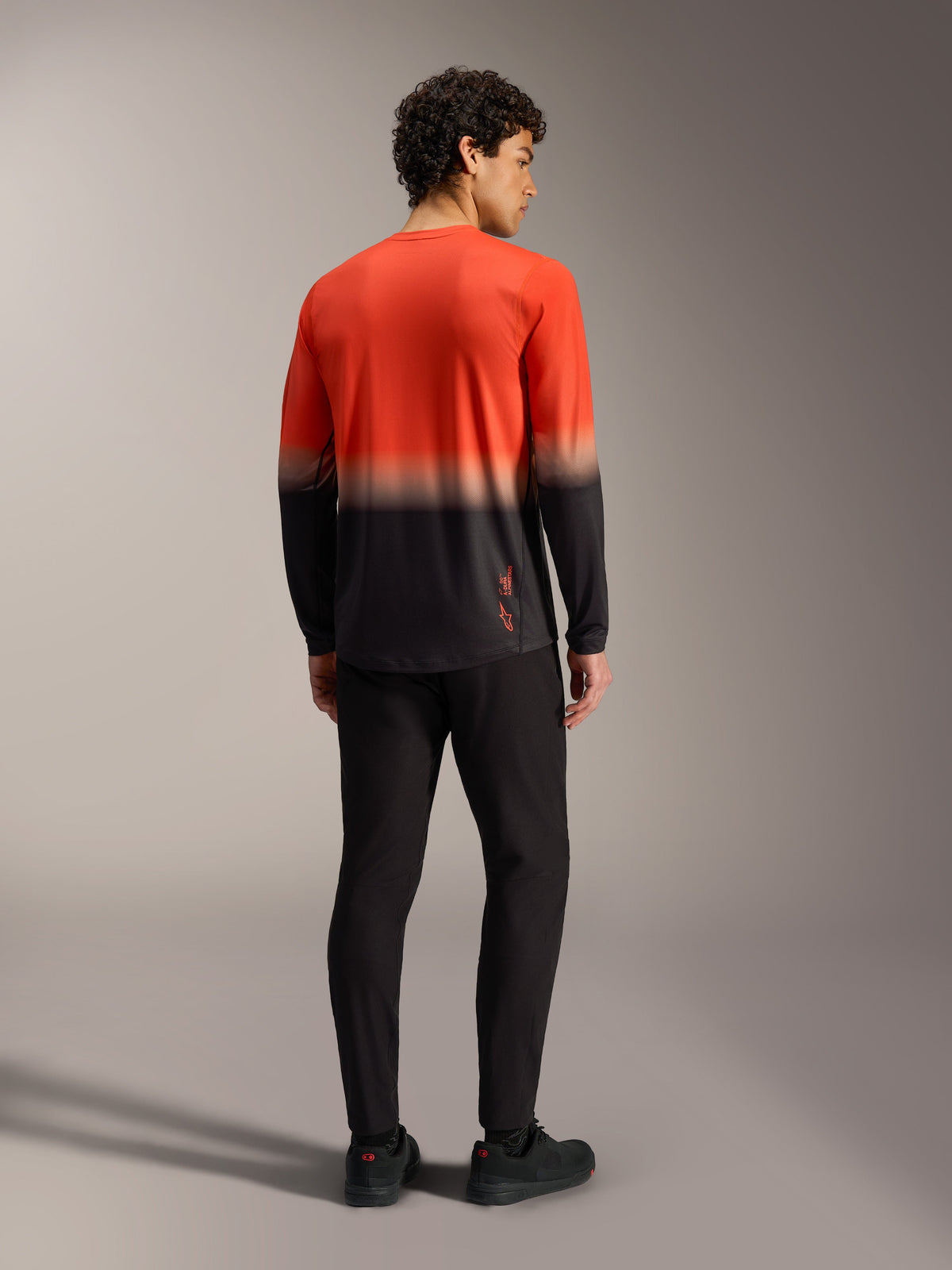 A-Dura ASTARS Long Sleeve Jersey 2.0 in orange and black gradient, performance mountain bike shirt shown from the back.