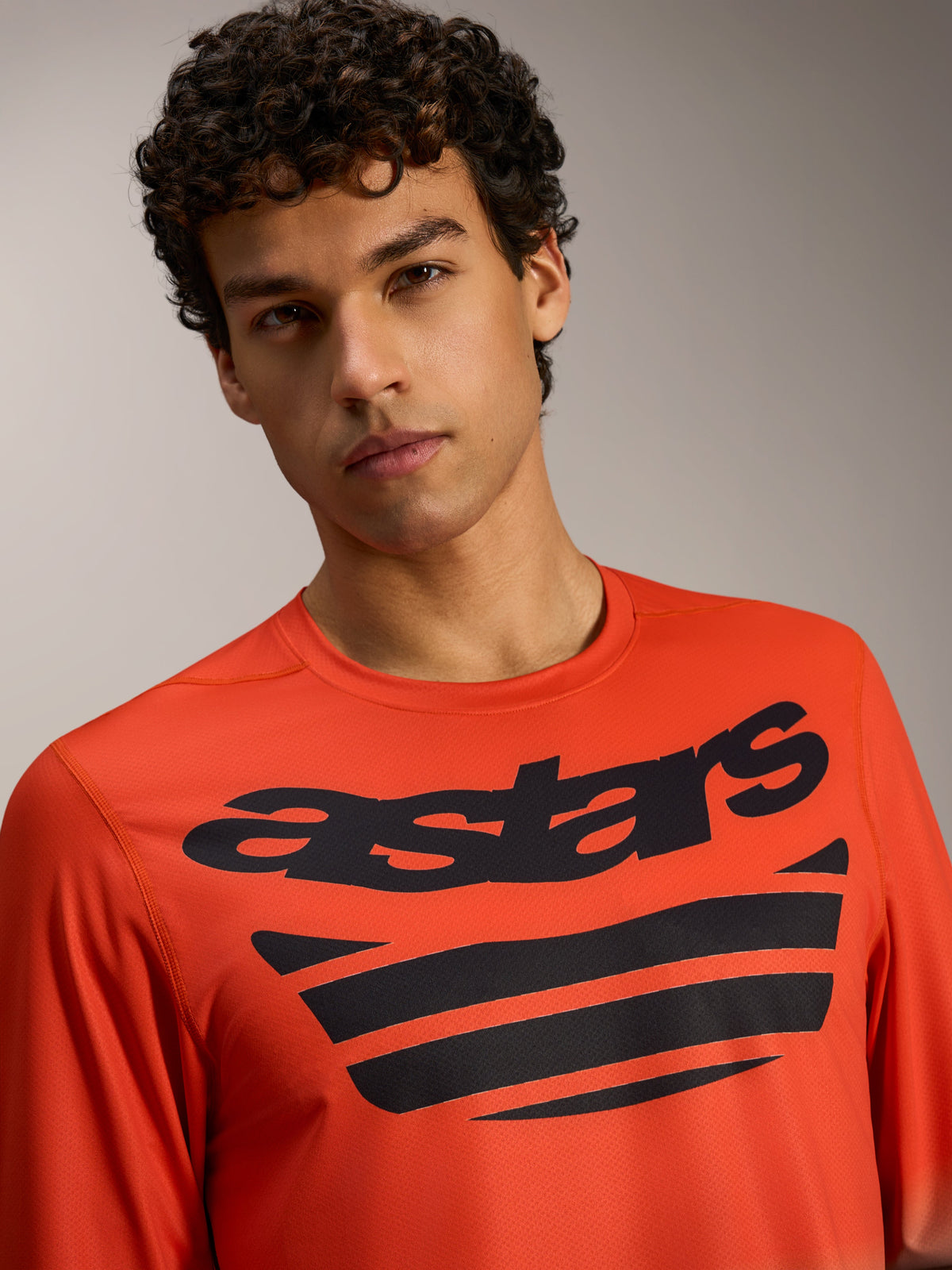 Orange A-Dura ASTARS Long Sleeve Jersey 2.0 with bold black chest logos, high-performance apparel for MTB trail riders.