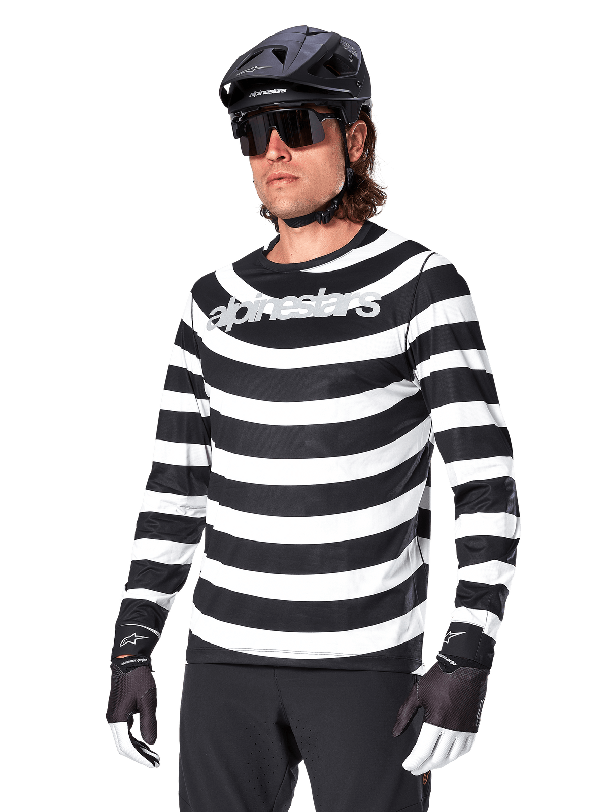 Alpinestars A-Aria Oscar Long Sleeve Jersey, MTB cycling jersey, Black and white horizontal stripes, worn with a black helmet and sunglasses, featuring Alpinestars branding on the chest, performance mountain bike apparel