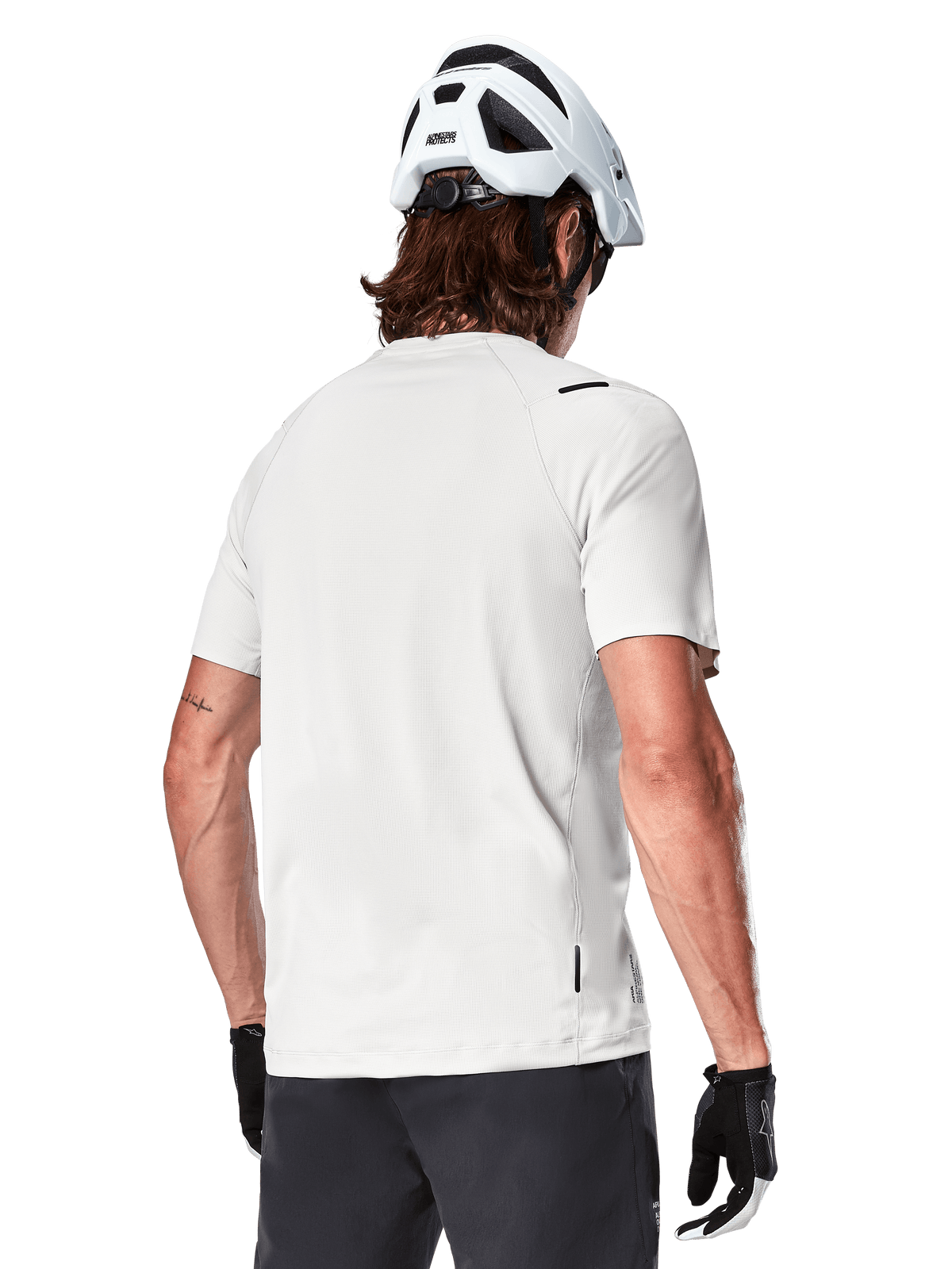 Alpinestars A-Aria Astar Jersey, Short Sleeve, White Dove, rear view of lightweight breathable mountain bike jersey, worn with a white helmet and black cycling gloves, featuring a dropped tail for extra coverage