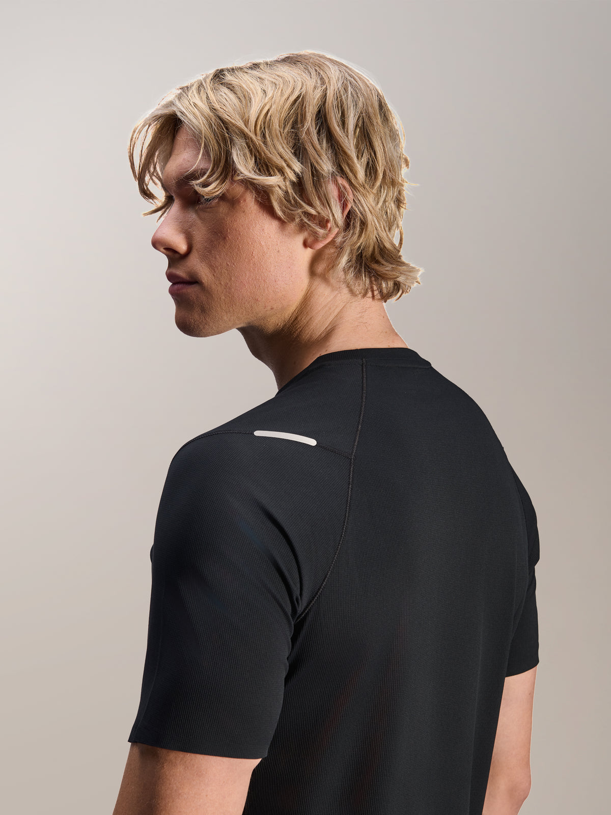 Man wearing Alpinestars A-Aria Switch Jersey, Short Sleeve, Black, view from the side and back showing the performance fit and shoulder detail, lightweight breathable MTB cycling apparel
