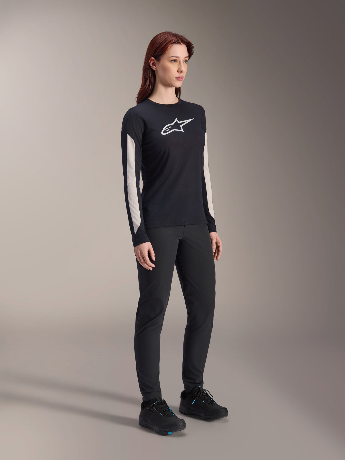Alpinestars Women Stella A-Dura Dri Astar Long Sleeve Jersey, Black, featuring white mesh sleeve panels and white Astar logo, worn with black pants and shoes, technical cycling activewear for mountain biking