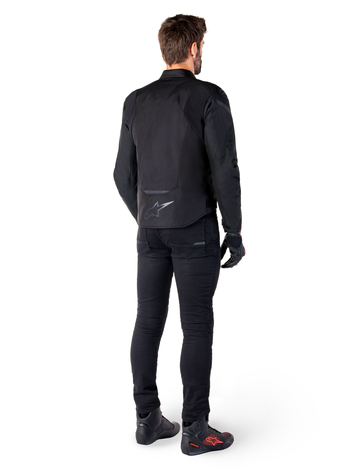 Alpinestars T-Jaws V4 Waterproof Jacket, Black, rear view on model wearing black riding pants and boots, showcasing the sport textile construction and Alpinestars logo on the lower back.