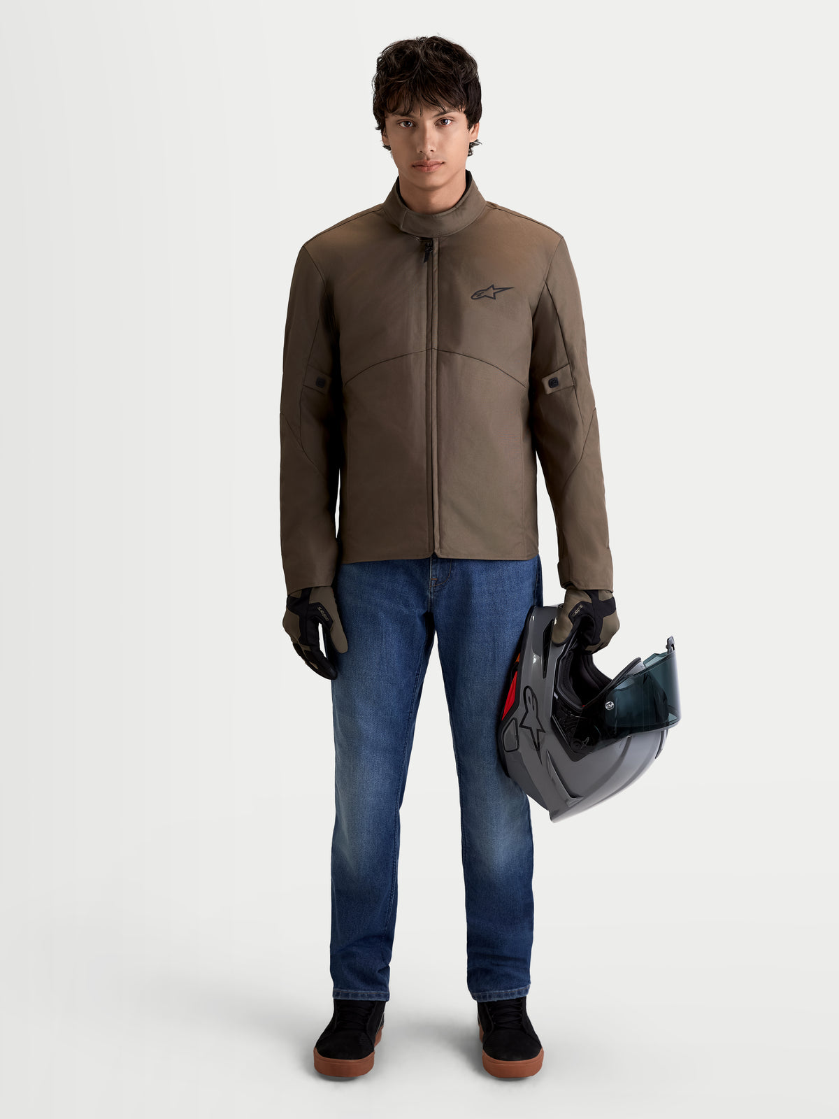 Alpinestars C-1 Waterproof Jacket, men's urban contemporary motorcycle textile jacket in walnut black, front view on a model wearing the jacket and holding a helmet, waterproof all-weather riding apparel.