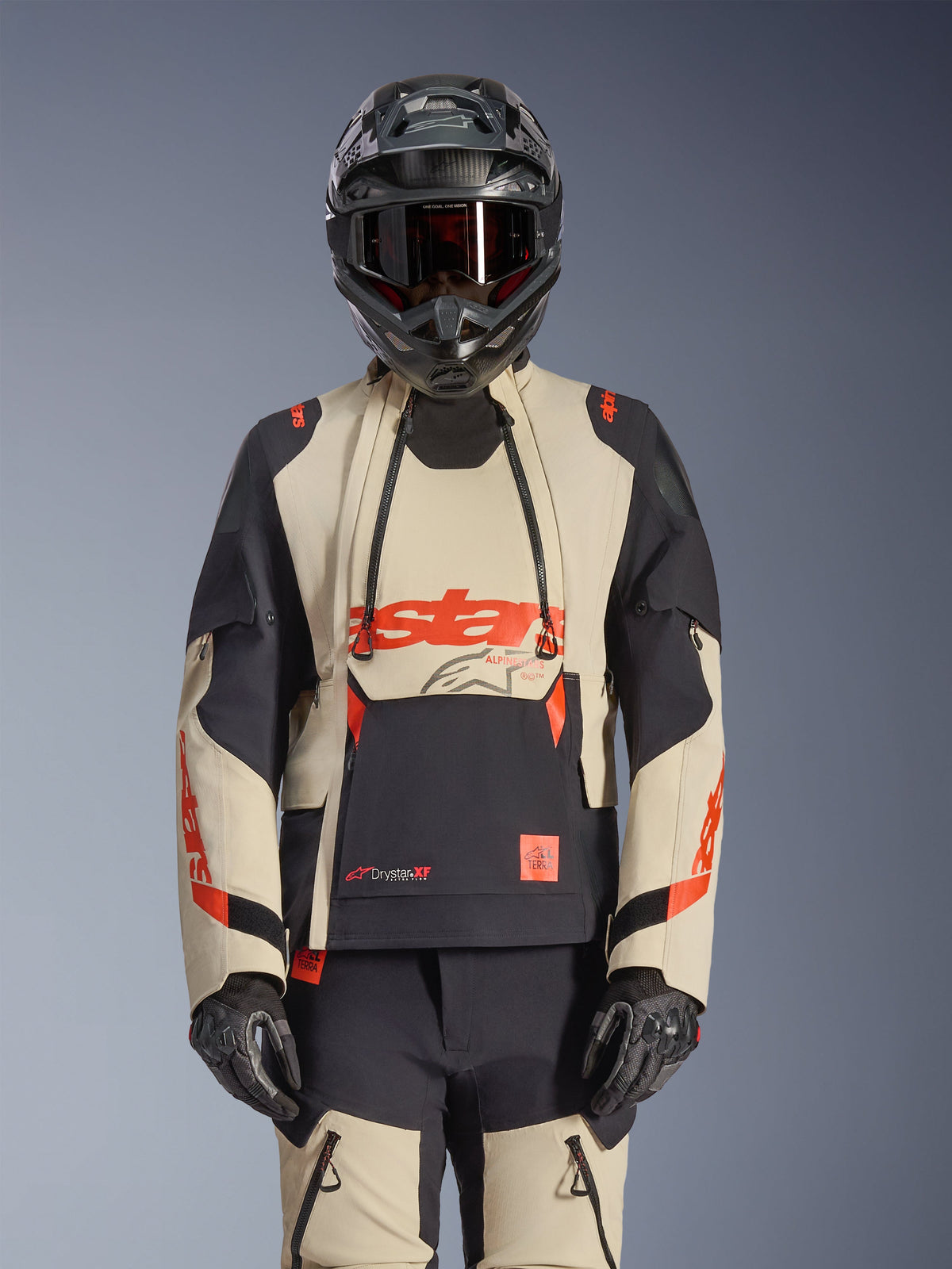 Alpinestars Halo Pro Drystar XF Laminated Jacket, adventure motorcycle jacket in Mastic Black and beige with red accents, worn with full protective gear including helmet and gloves, featuring modular ventilation panels and 3L laminated construction.
