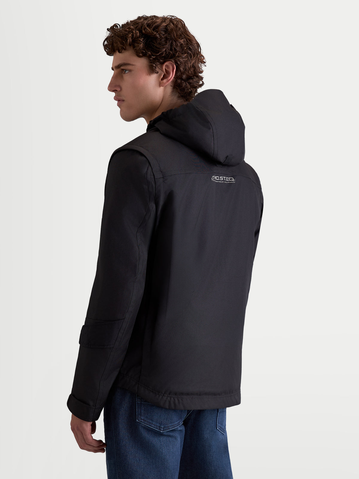 Alpinestars Morfex Parka Waterproof Jacket, men's urban contemporary motorcycle jacket in black, rear three-quarter view on a model wearing the textile jacket with integrated hood