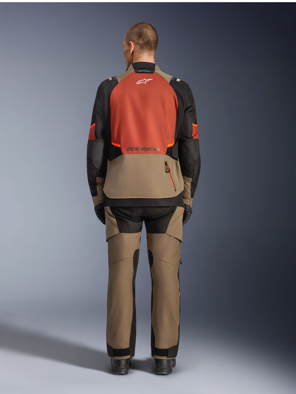 Alpinestars Andes V4 Drystar® Jacket, Walnut Rust Black, rear view of motorcycle touring jacket featuring rust-colored upper back panel and walnut lower section, worn with matching adventure pants and black boots