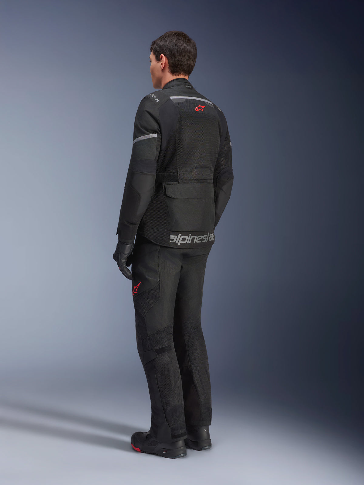 Alpinestars Andes Air Drystar® Pants and matching jacket, Black with red star logos, adventure touring motorcycle gear shown from the back, featuring mesh ventilation panels and reflective details.