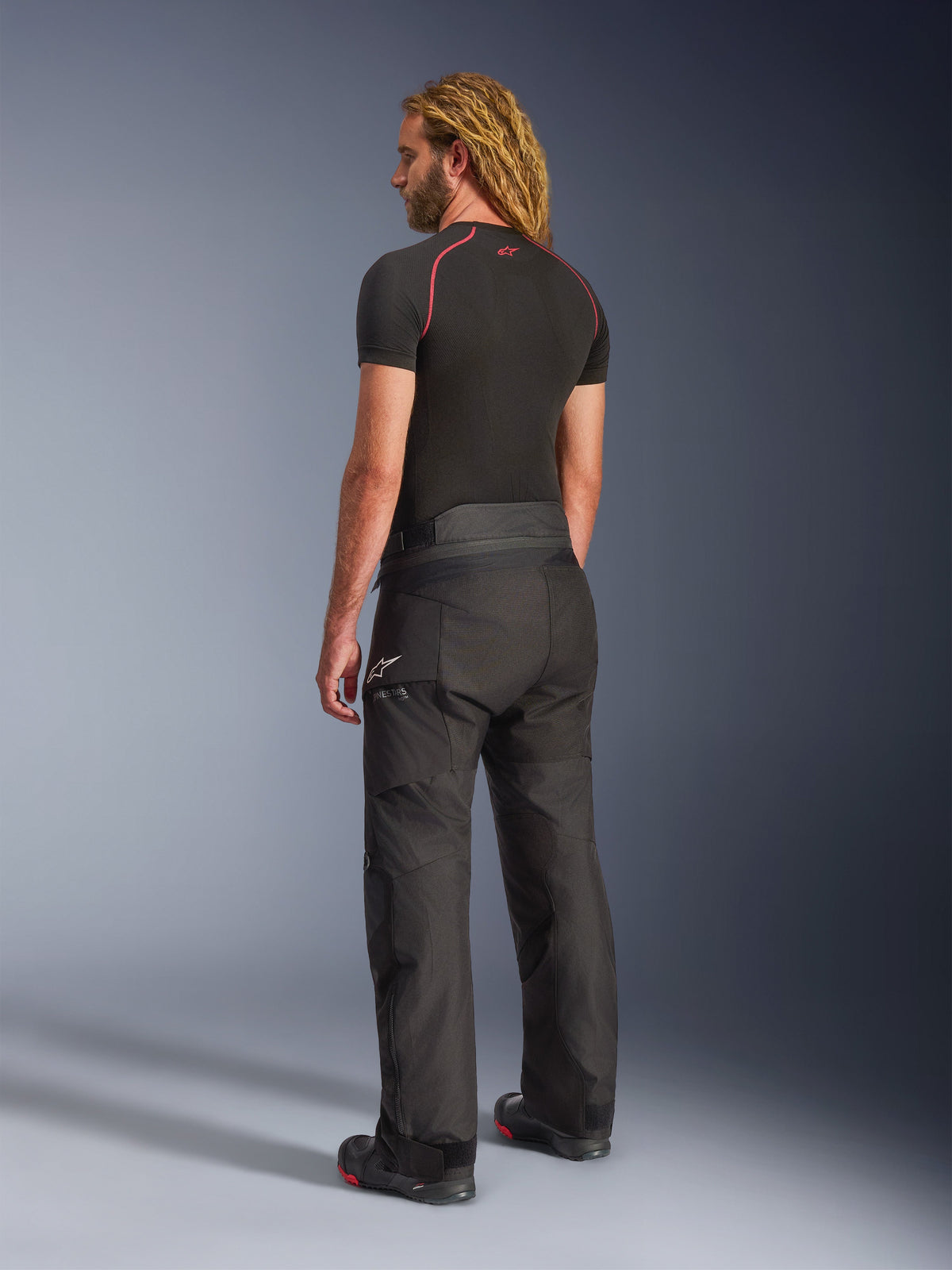 Alpinestars Andes V4 Drystar® Pants - Long, Adventure Motorcycle Pants, Black, rear three-quarter view on model, durable textile design with reinforced seat and knee panels, featuring Alpinestars star logo, worn with black base layer and riding boots