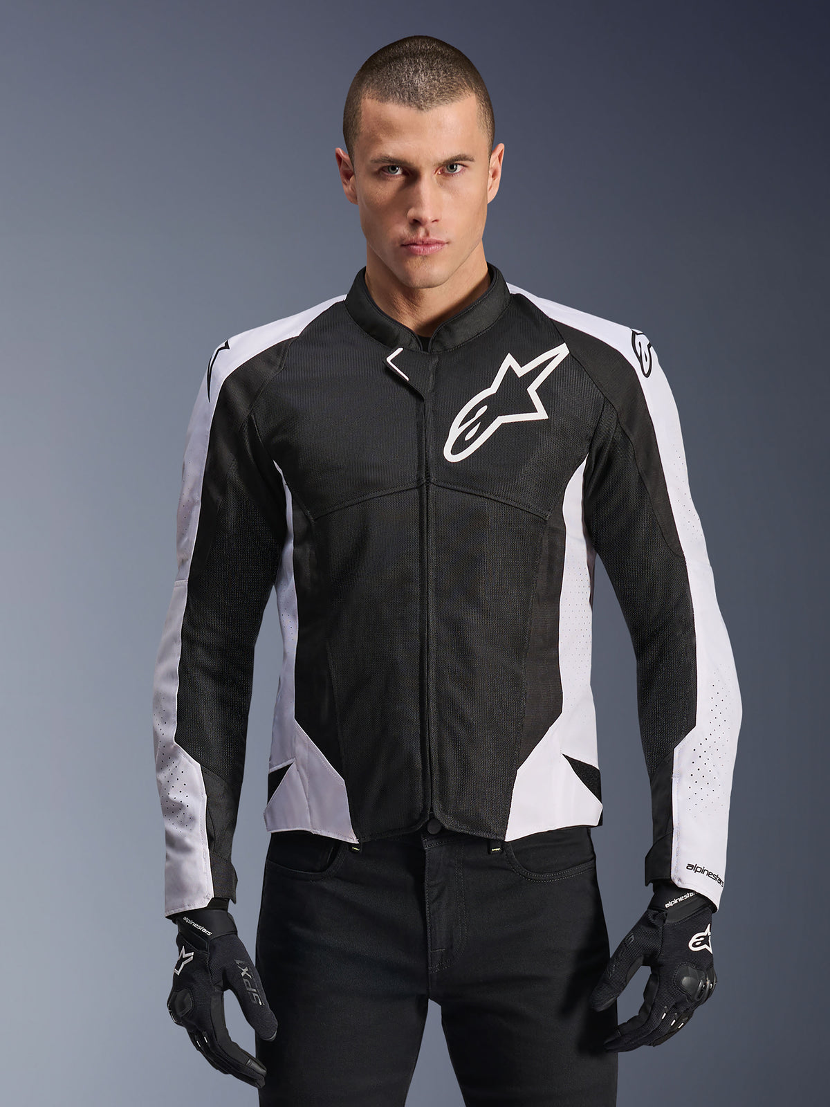 Alpinestars Viper Air V4 Jacket, Motorcycle Racing Jacket, Black and White, worn by rider, tech mesh and textile construction with white shoulder panels, prominent star logo on chest, sport performance design, paired with black riding gloves