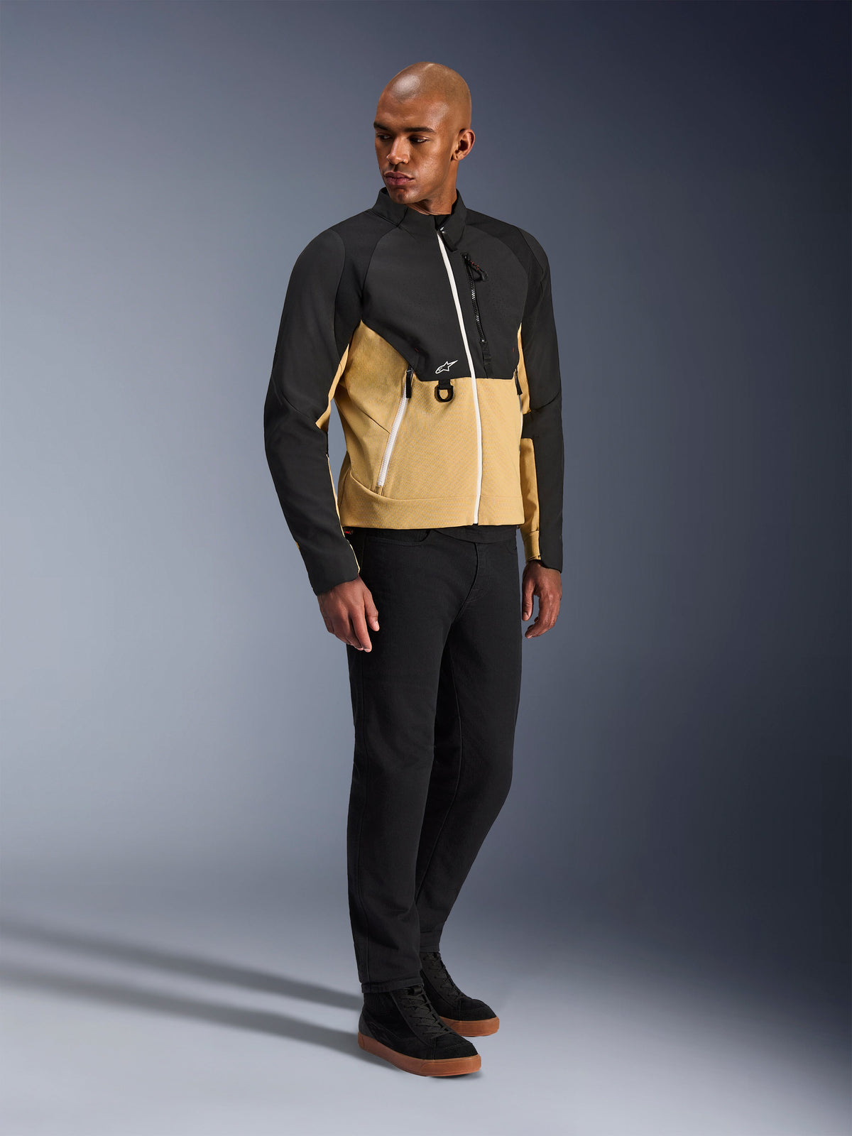 Alpinestars Provoke Jacket, urban motorcycle jacket, Black Camel, worn by a model with black pants and sneakers, two-tone textile design with black upper and camel lower torso, white zipper details, contemporary urban riding gear