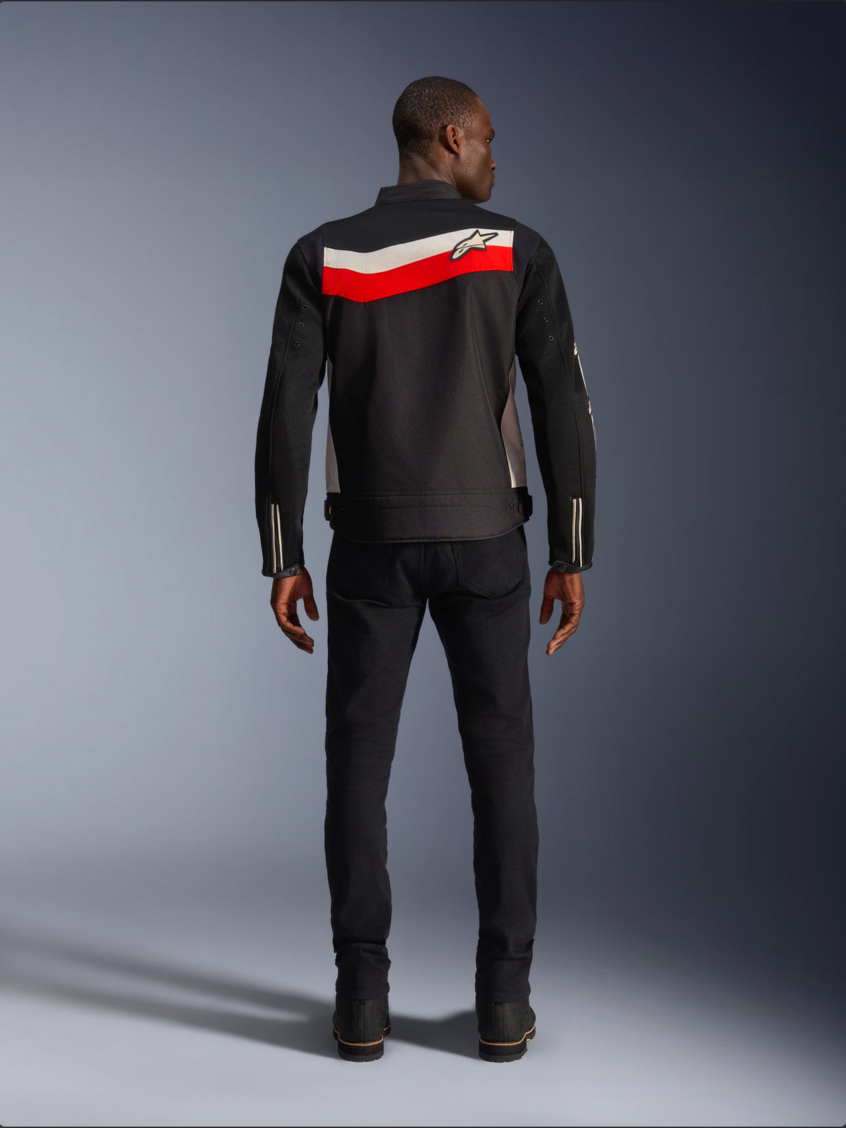 Alpinestars T-Dyno Air Jacket, Men's Textile Motorcycle Jacket, Rear view, Black with Bright Red and Ecru horizontal stripes across the back, Alpinestars logo on the yoke, worn with black pants and boots, breathable 3D mesh construction