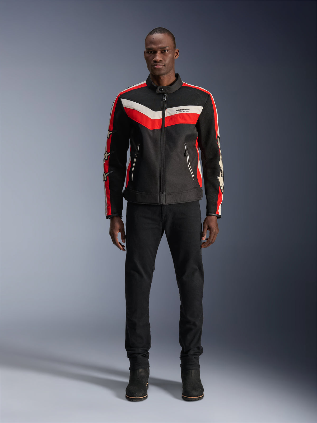 Alpinestars T-Dyno Air Jacket, Textile Motorcycle Jacket, Black Bright Red and Ecru, worn by a model with black pants and boots, featuring a vintage-inspired design with bold color stripes on the chest, star logos on the sleeves, and breathable mesh construction for urban riding.