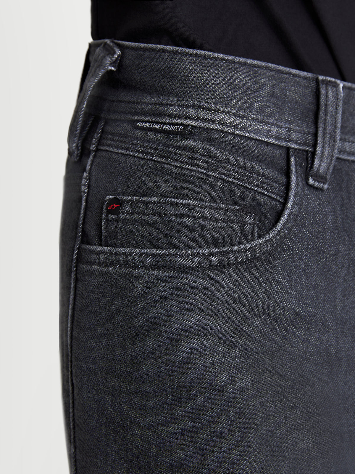 Alpinestars Flex-AST 7 Denim Pants, men's urban riding denim in faded black, close-up view showing pocket construction, branded rivet detail, and Alpinestars Protects woven label