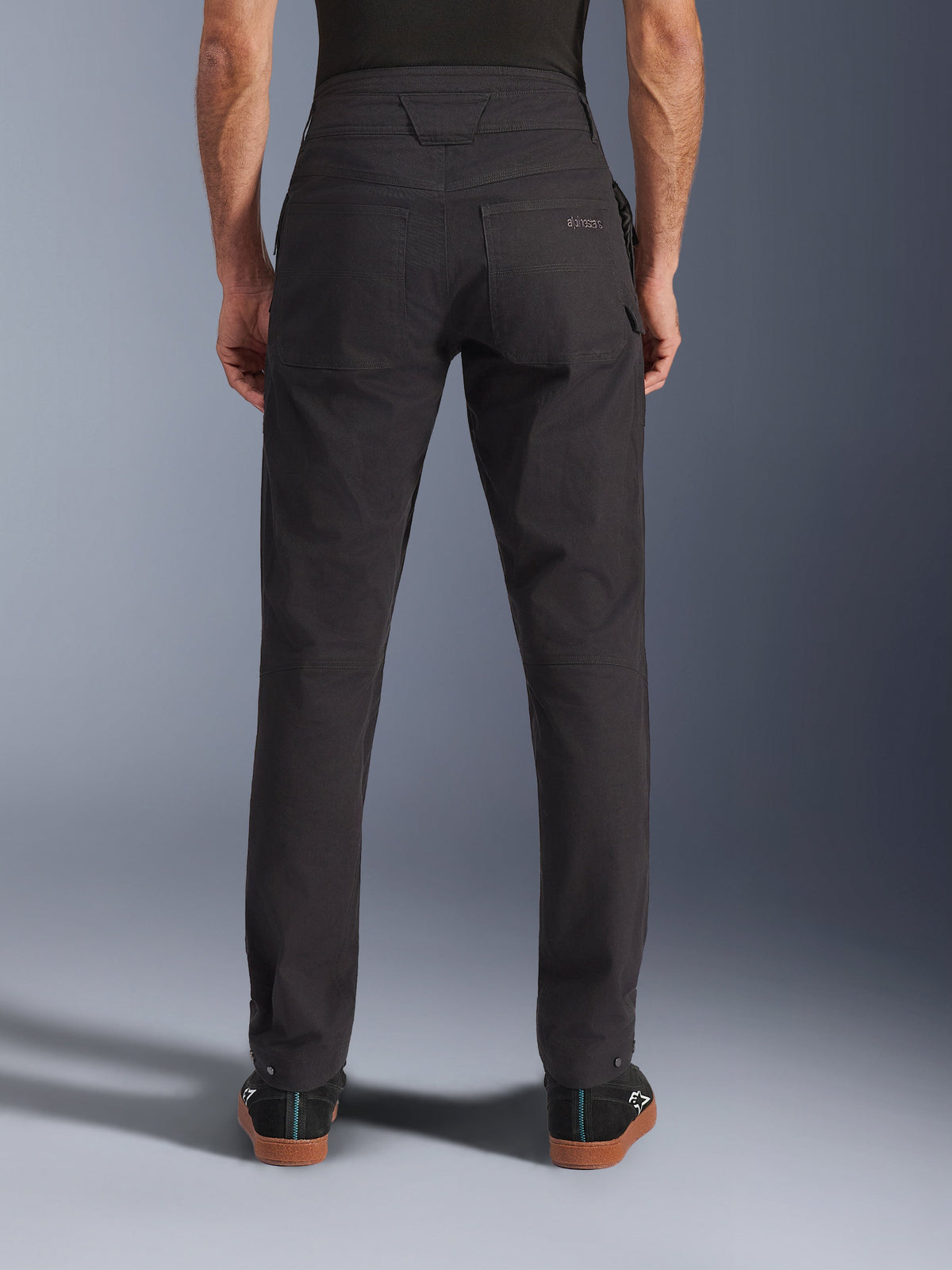 Alpinestars Flex-AST Canvas Pants, Urban Motorcycle Pants, Black, back view showing rear pockets with embroidered logo, extended back rise, and ergonomic leg seams, worn with casual black footwear