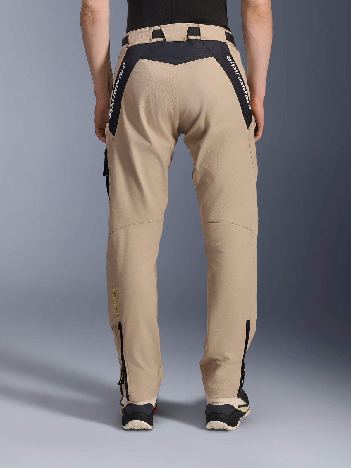Alpinestars Acteon Pants, Urban Motorcycle Pants, Sand, rear view featuring black ripstop panels with white branding on the yoke, tapered fit with lower leg zippers, contemporary road riding gear