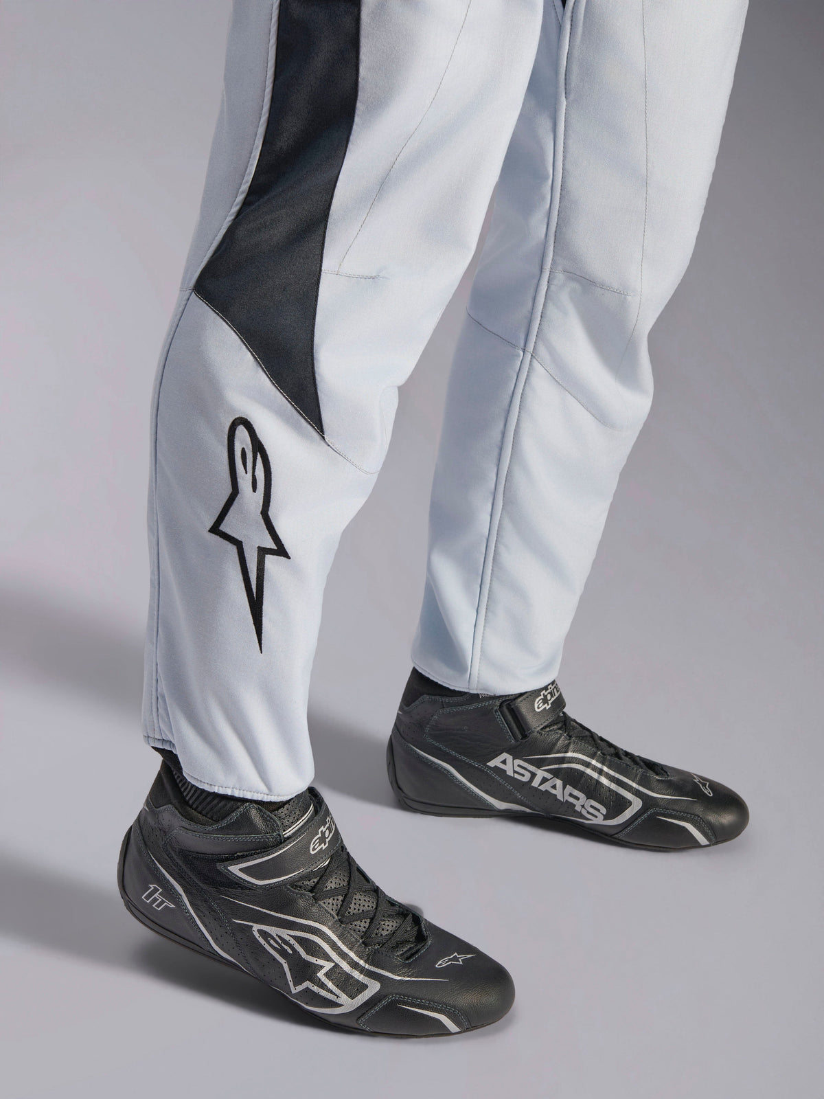 Alpinestars GP Pro Comp V2 FIA Suit, Gray and Black Auto Racing Suit with leg star logo and racing boots.