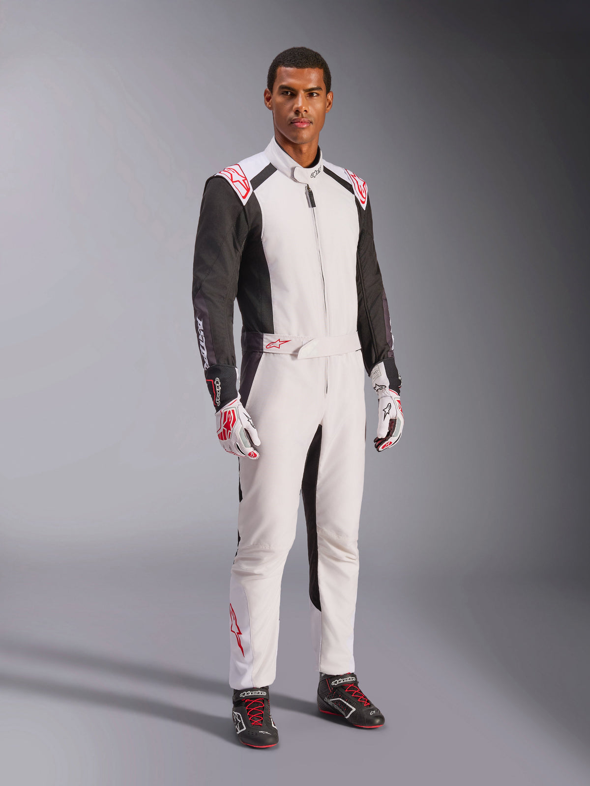 Alpinestars KMX-5 V3 Suit, White Black and Bright Red, one-piece karting suit worn with matching white and red gloves and black racing shoes, featuring black sleeves and bold red accents, professional motorsport gear for competitive karting