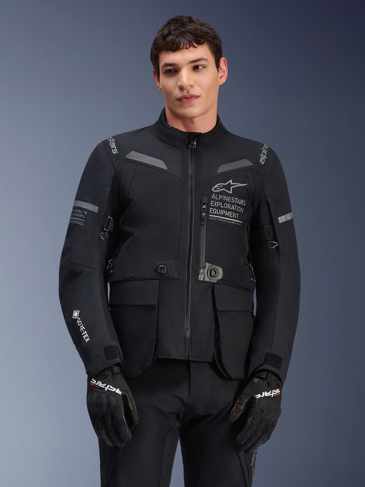 Alpinestars ST-7 2L GORE-TEX Jacket, Motorcycle Touring Jacket, Black and Dark Gray, featuring Alpinestars Exploration Equipment chest branding, large waterproof cargo pockets, GORE-TEX sleeve logo, rugged adventure-ready design with reflective accents
