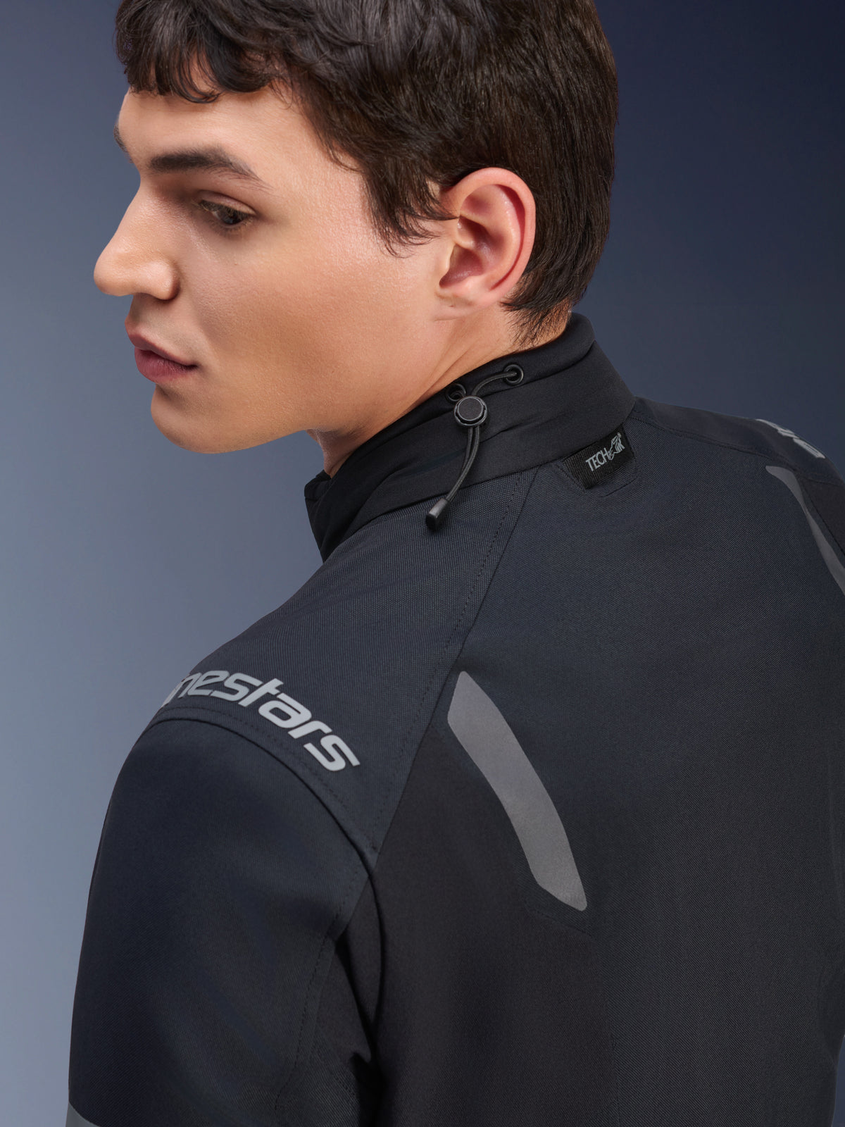 Alpinestars ST-7 2L GORE-TEX Jacket, Black and Dark Gray motorcycle jacket, close-up view of the collar showing the shock cord adjustment and Tech-Air label, featuring grey reflective accents and brand logo on the shoulder.