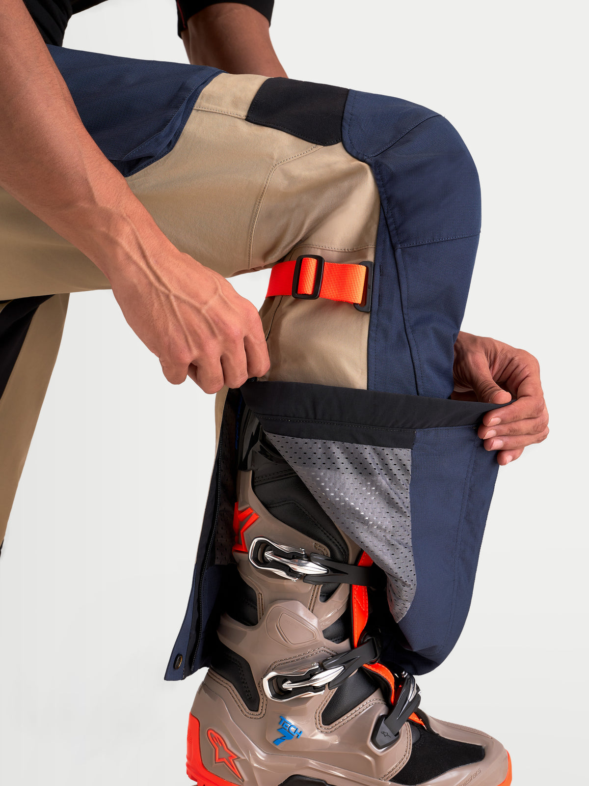 Alpinestars Arenis Gore-Tex Pants, men's adventure touring motorcycle pants in night navy and aluminum, close-up view showing lower-leg adjustable gusset zipper and matching boots worn by a model.