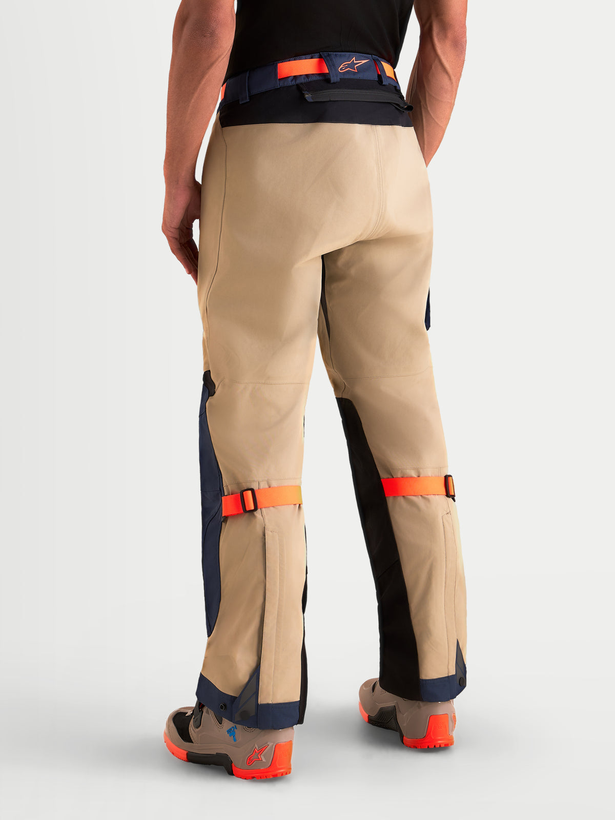 Alpinestars Arenis Gore-Tex Pants, men's adventure touring motorcycle pants in khaki, navy, and orange, rear view on a model showing reinforced seat construction and waist belt, AA certified waterproof all-terrain riding apparel