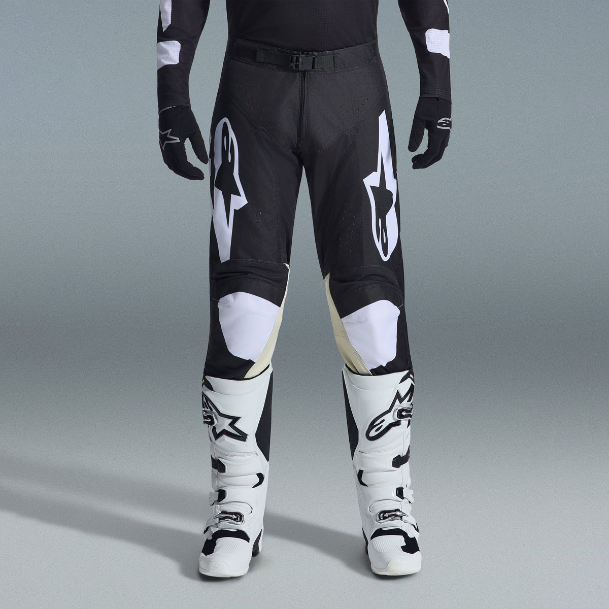 Alpinestars 2026 Racer Air Riway Gear Set, Black and White motocross pants with tan inner knee panels, paired with white racing boots and black gloves, lightweight ventilated off-road racing gear