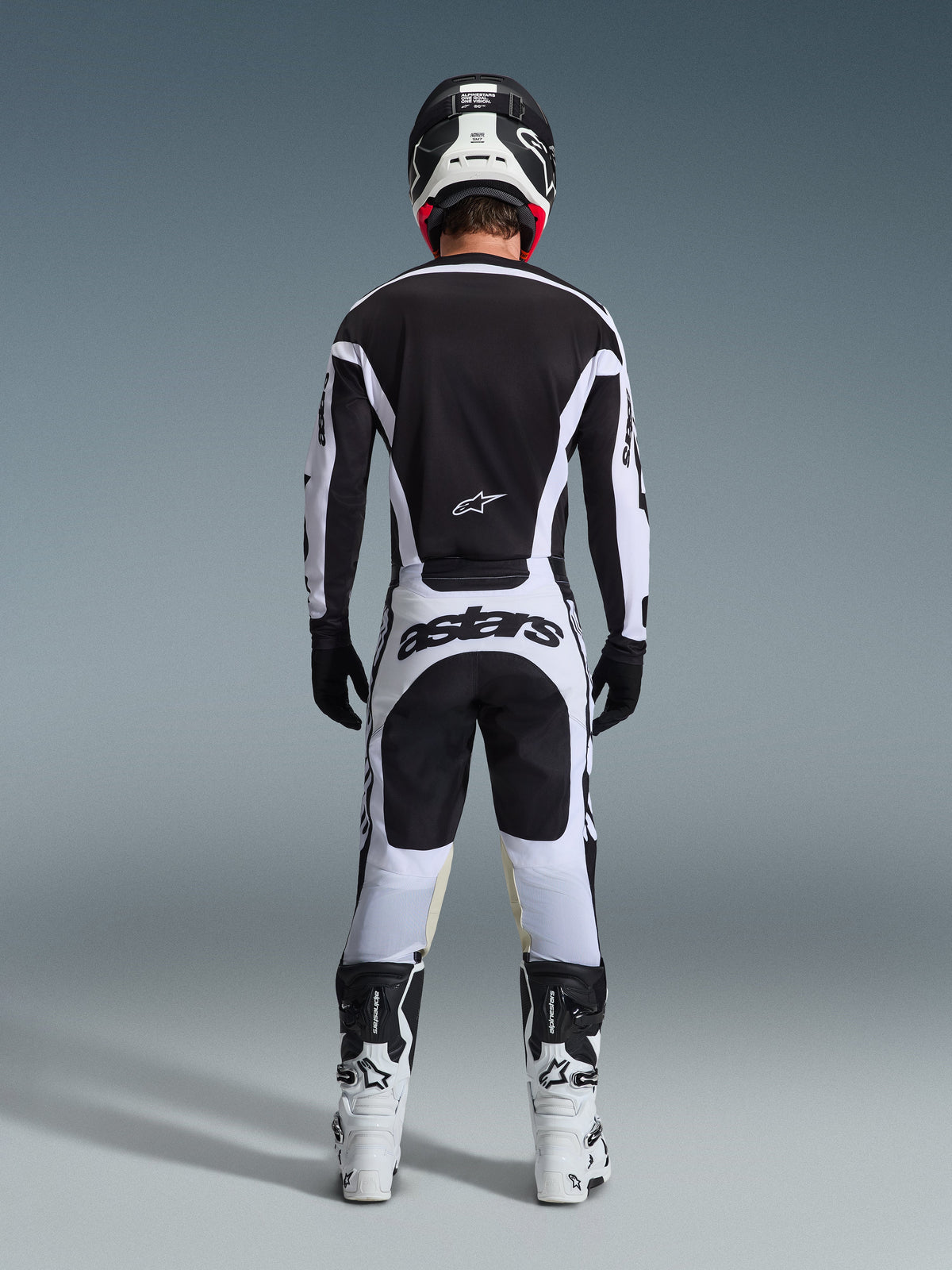 Alpinestars 2026 Racer Riway Pants, Motocross Pants, White and Black, rear view of complete racing gear set, bold 'astars' branding on the seat, worn with matching jersey, white boots, and black helmet, coordinated off-road racing outfit.