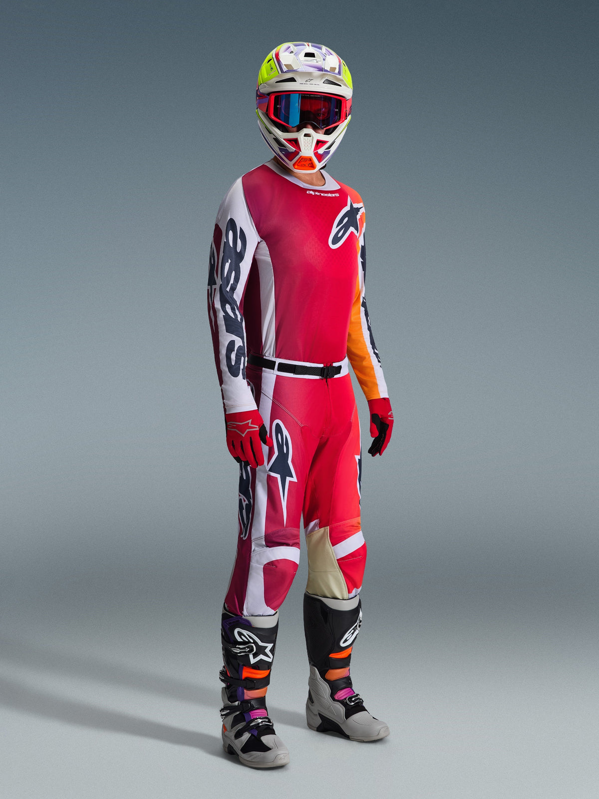 Alpinestars 2026 Racer Portl Pants, Motocross Pants, Red Light Gray and Dark Gray, worn as part of a full racing gear set with matching jersey, red gloves, colorful helmet with blue goggles, and gray boots, durable construction for off-road motocross performance.