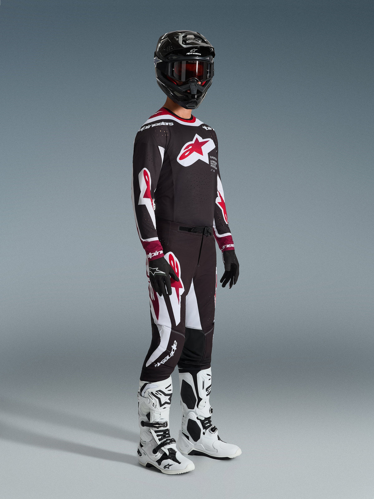 Alpinestars 2026 Supertech AFD Vista Pants, Motocross Pants, Black Red and White, worn with matching racing jersey, black helmet with red goggles, black gloves, and white boots, athletic performance gear for off-road racing