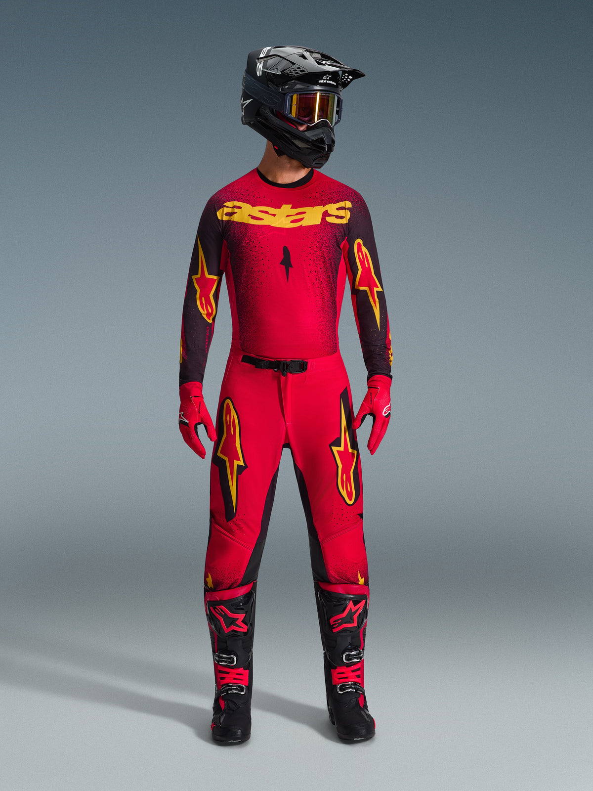 Alpinestars 2026 Supertech Scenz Pants, Motocross Pants, Red Black and Yellow, worn by a rider in a complete racing gear set, matching red and black jersey with yellow logos, black helmet, red gloves, and black boots, athletic pro-fit design for off-road competition