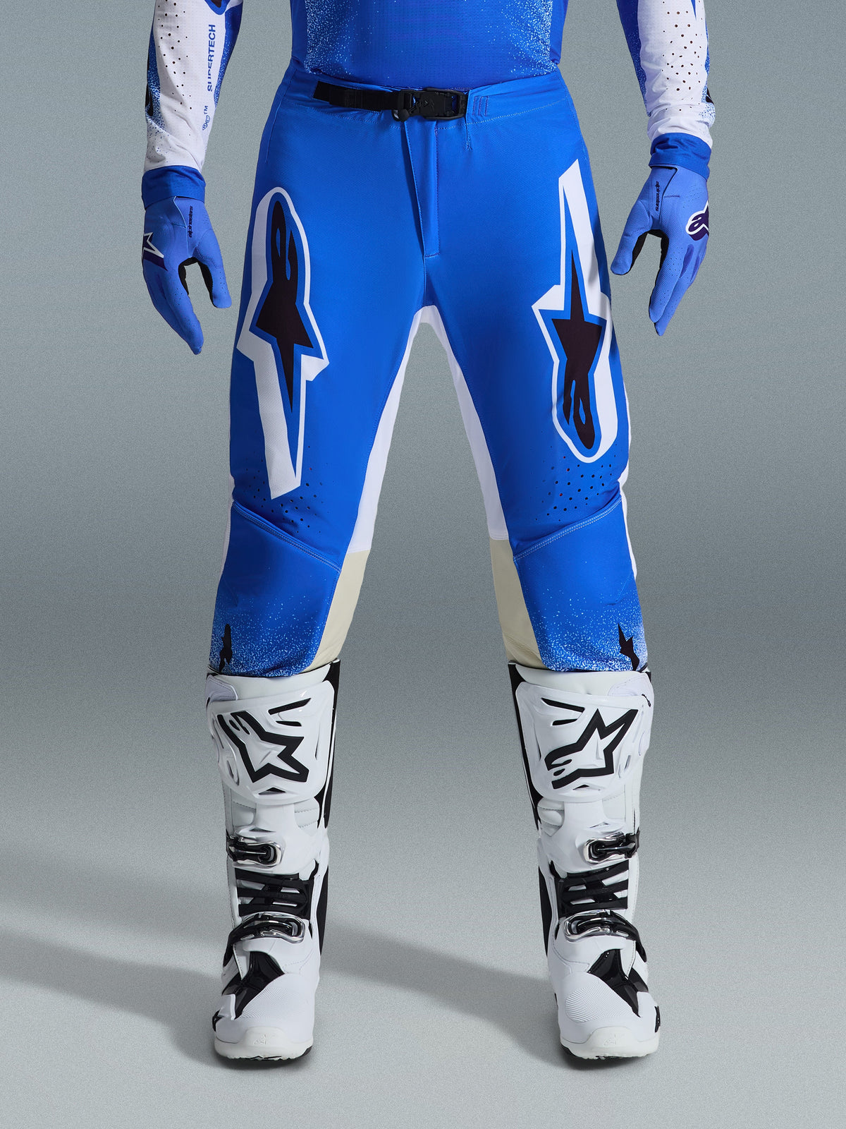 Alpinestars 2026 Supertech Scenz Pants, Motocross Pants, Ucla Blue White, worn with matching blue gloves and white boots, featuring large white and black graphics on the thighs, athletic fit for off-road performance