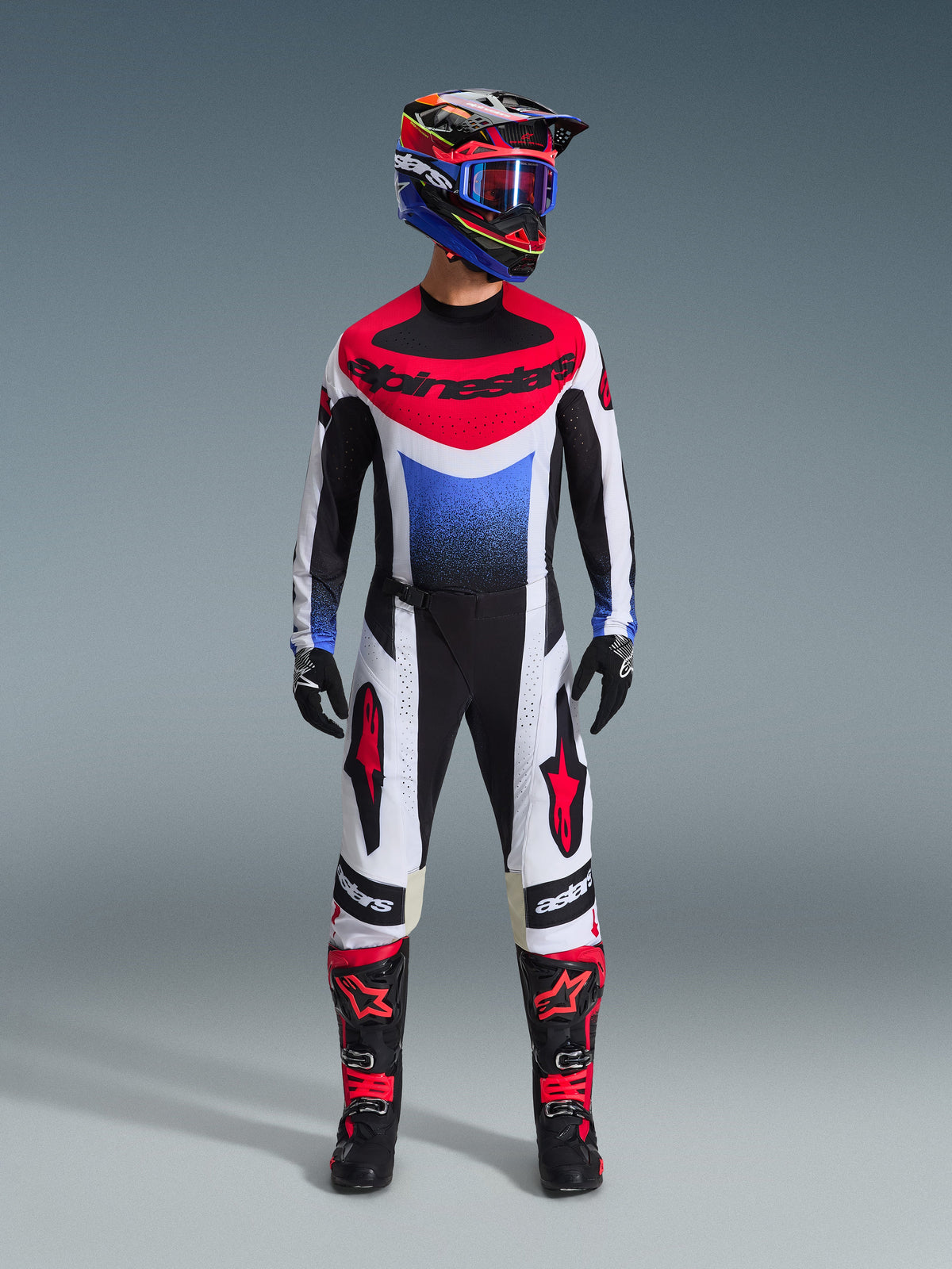 Alpinestars 2026 Techstar Knif Pants, Motocross Pants, Black White and Red, worn as part of a full racing gear set with matching jersey and helmet, featuring red star logos on the thighs and a sleek athletic fit for off-road racing