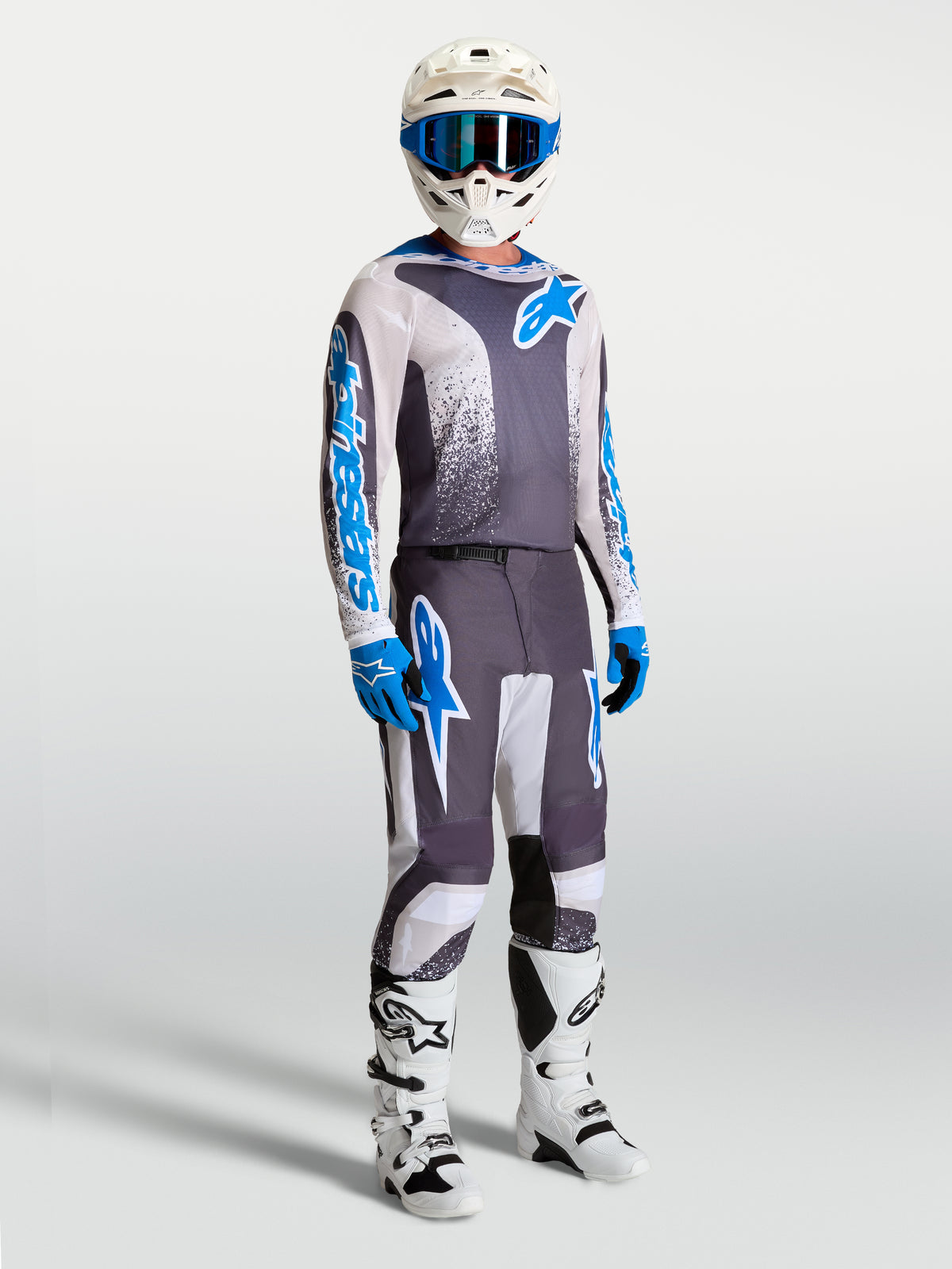 Alpinestars Fluid Drag Pants and gear set, gray and blue motocross apparel with an ergonomic 3D design for performance.