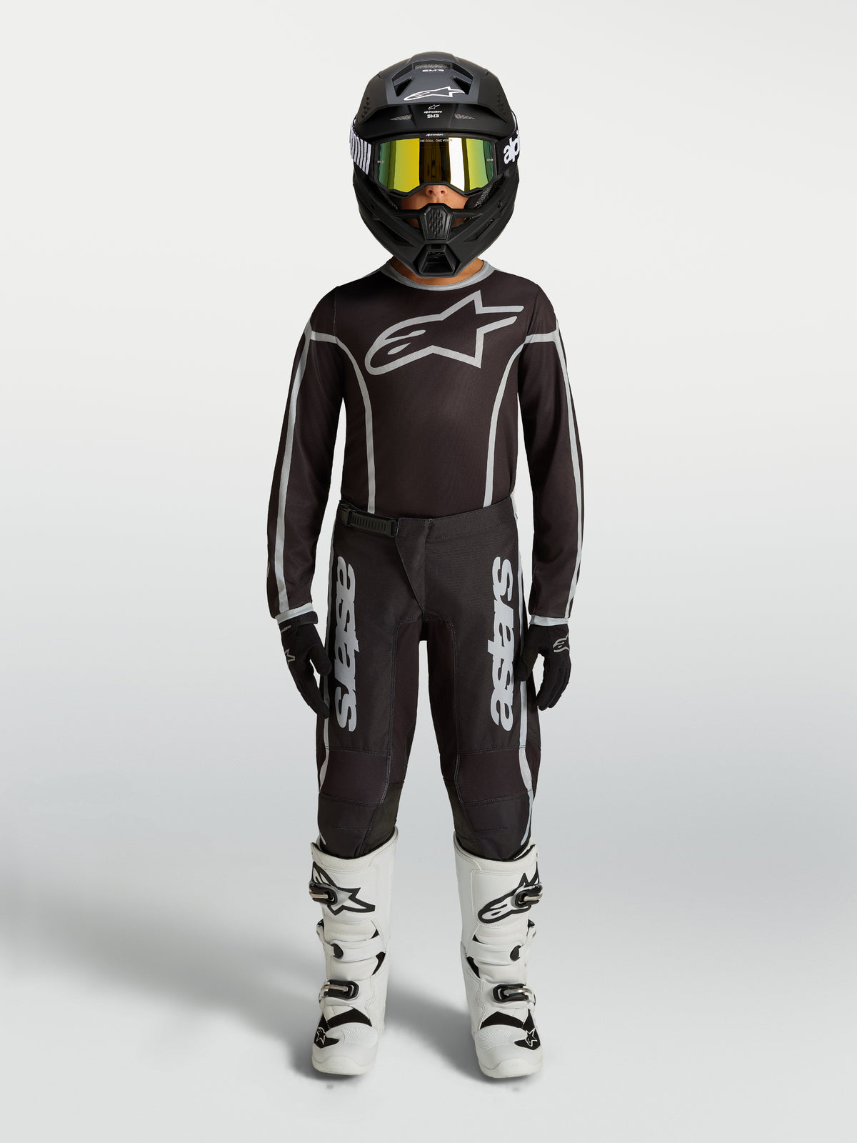 Alpinestars Youth Fluid Apex V2 Pants, black and silver motocross gear set with matching jersey and white boots.