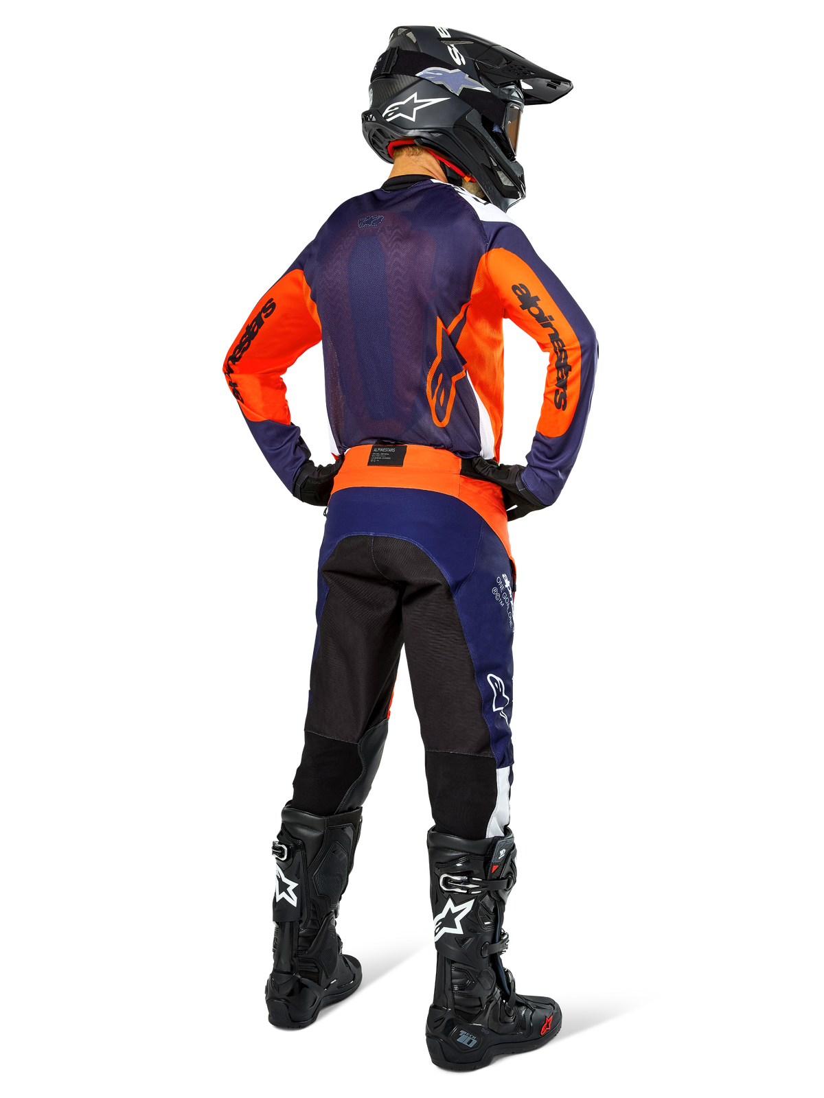 Motocross rider from the back wearing Alpinestars Pro-Dura Jersey, Navy Hot Orange and White, matching navy and orange pants, black helmet and black boots, featuring breathable mesh back panel and elongated rear, coordinated gear for enduro racing