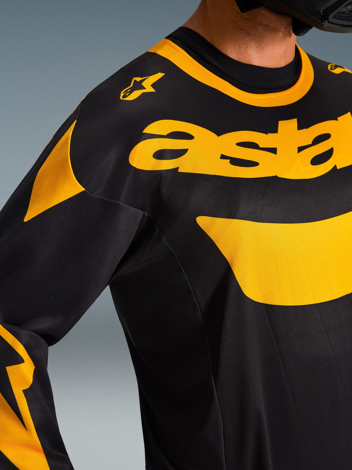 Alpinestars 2026 Racer Riway Jersey, Motocross Jersey, Yellow and Black, close-up shot of chest and shoulder area, featuring bold yellow 'astars' branding and graphic accents on black polyfabric, performance off-road gear.