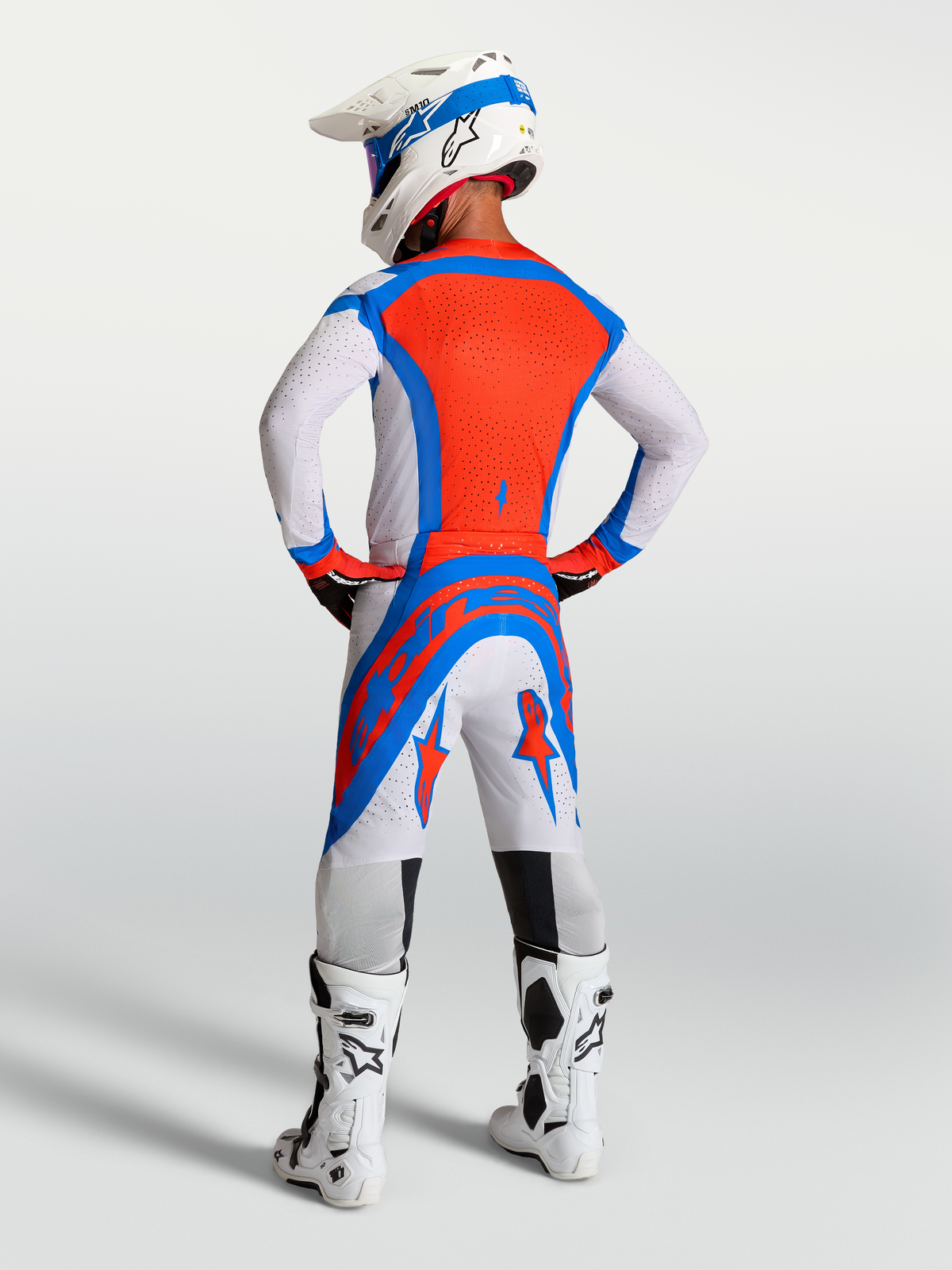 Alpinestars Supertech Vesta Motocross Gear Set, Light Lilac and Cardinal Red, rear view on rider with helmet and boots.