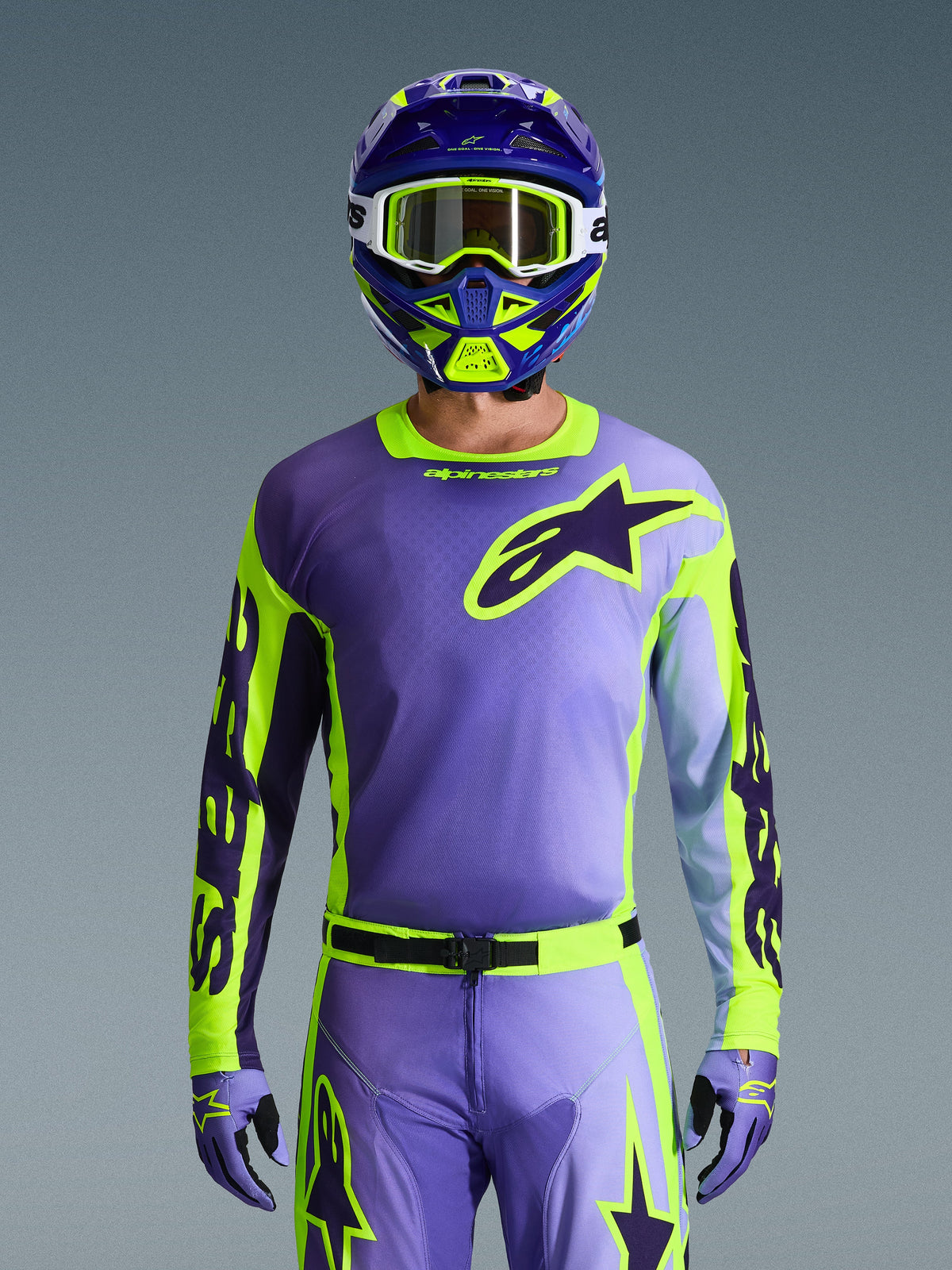 Alpinestars 2026 Racer Portl Gear Set, full motocross racing gear in purple and lime green, featuring a purple jersey with neon yellow sleeves and dark purple Astar logo, matching purple and green helmet with white goggles, and coordinated pants and gloves for off-road riding.